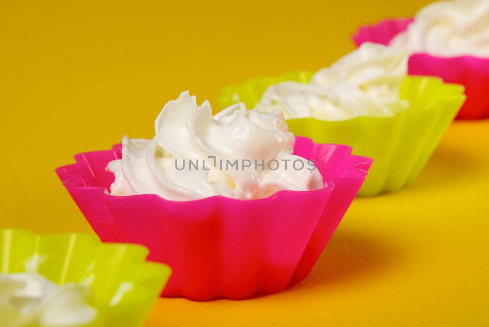 Four portions of whipped cream over yellow background. Shallow DOFÓ