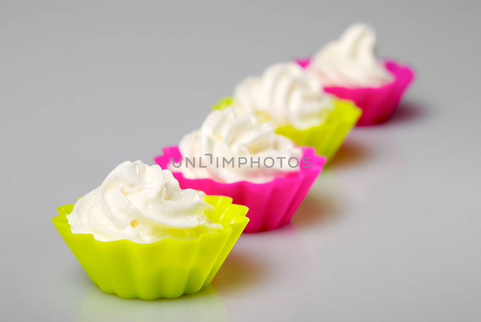 Four portions of whipped cream over white background. 