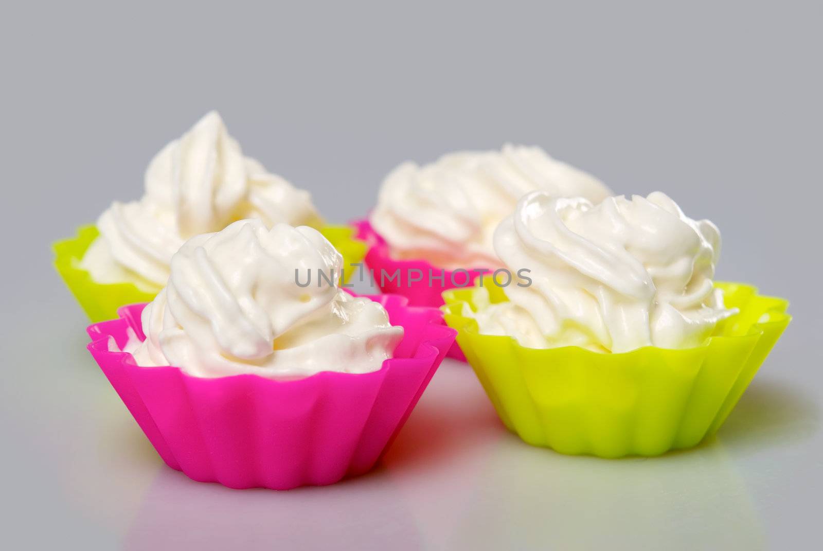 Four portions of whipped cream over white background. 