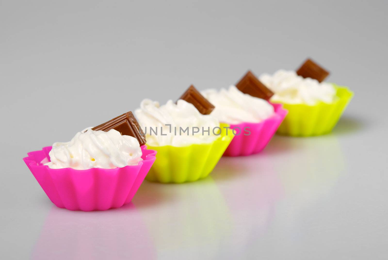 Four portions of whipped cream over white background. 