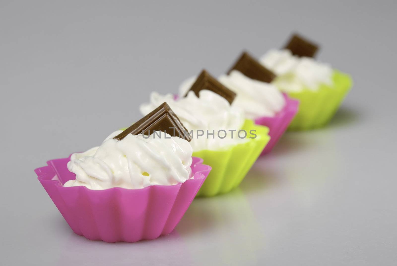 Four portions of whipped cream over white background. 