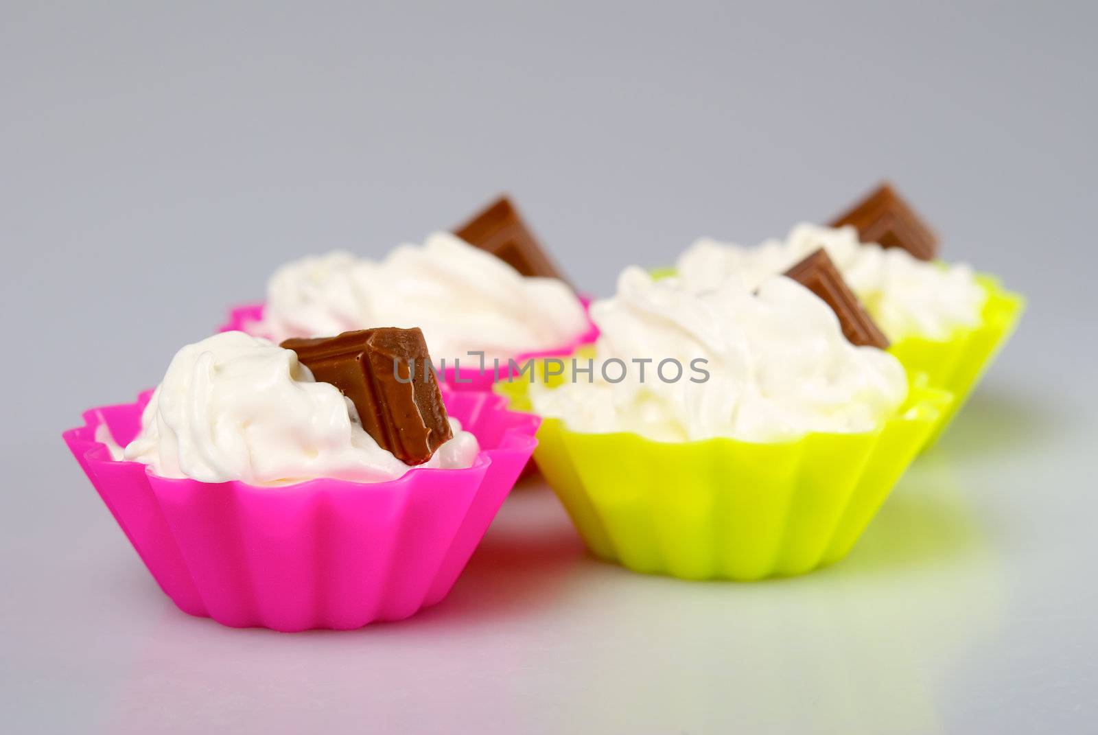 Four portions of whipped cream over white background. 