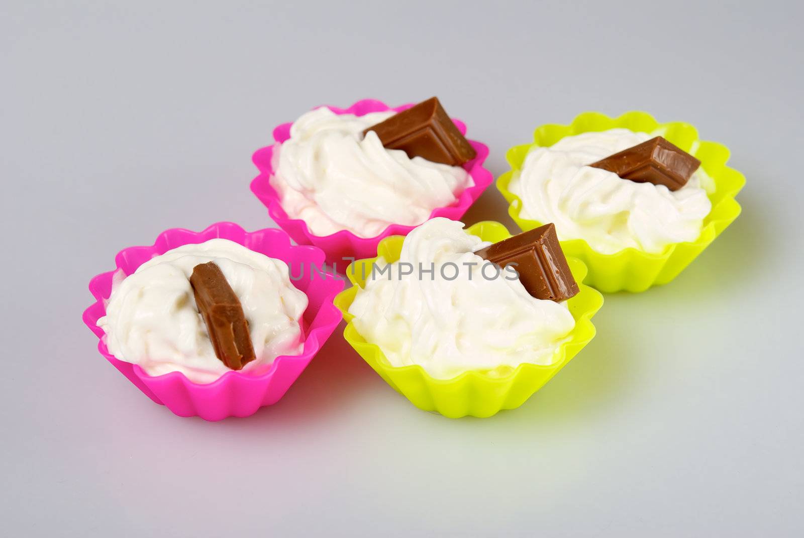 Four portions of whipped cream over white background. 