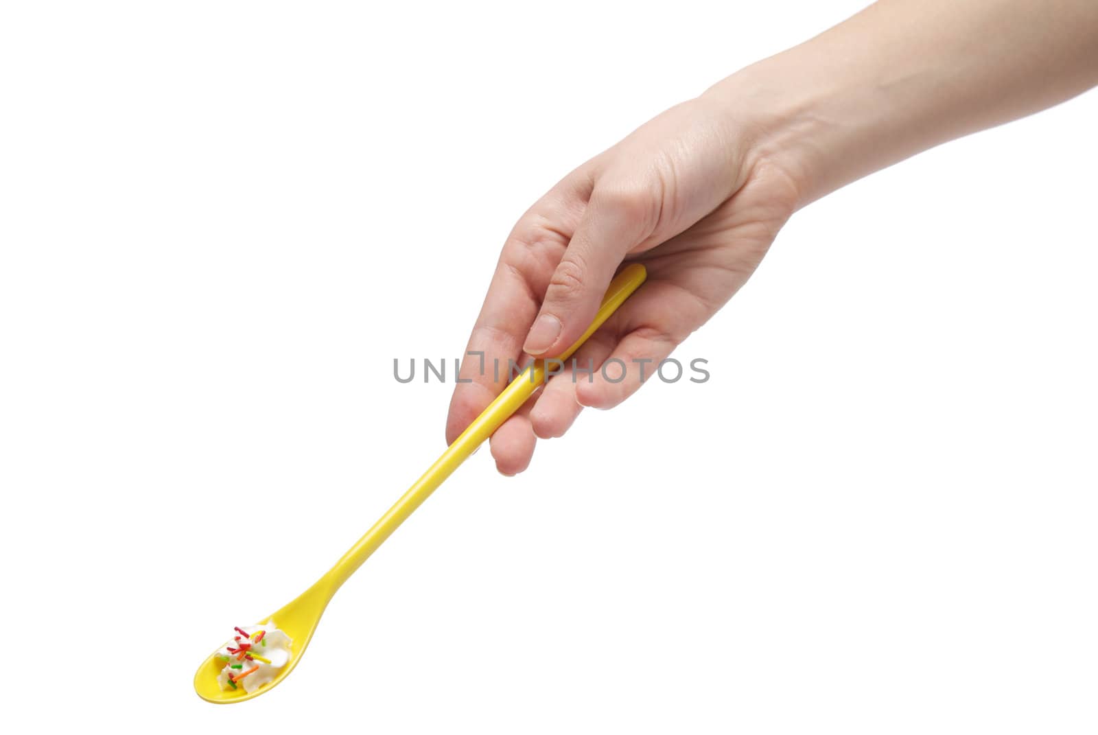 Hand holding a teaspoon full of cream, isolated on white background