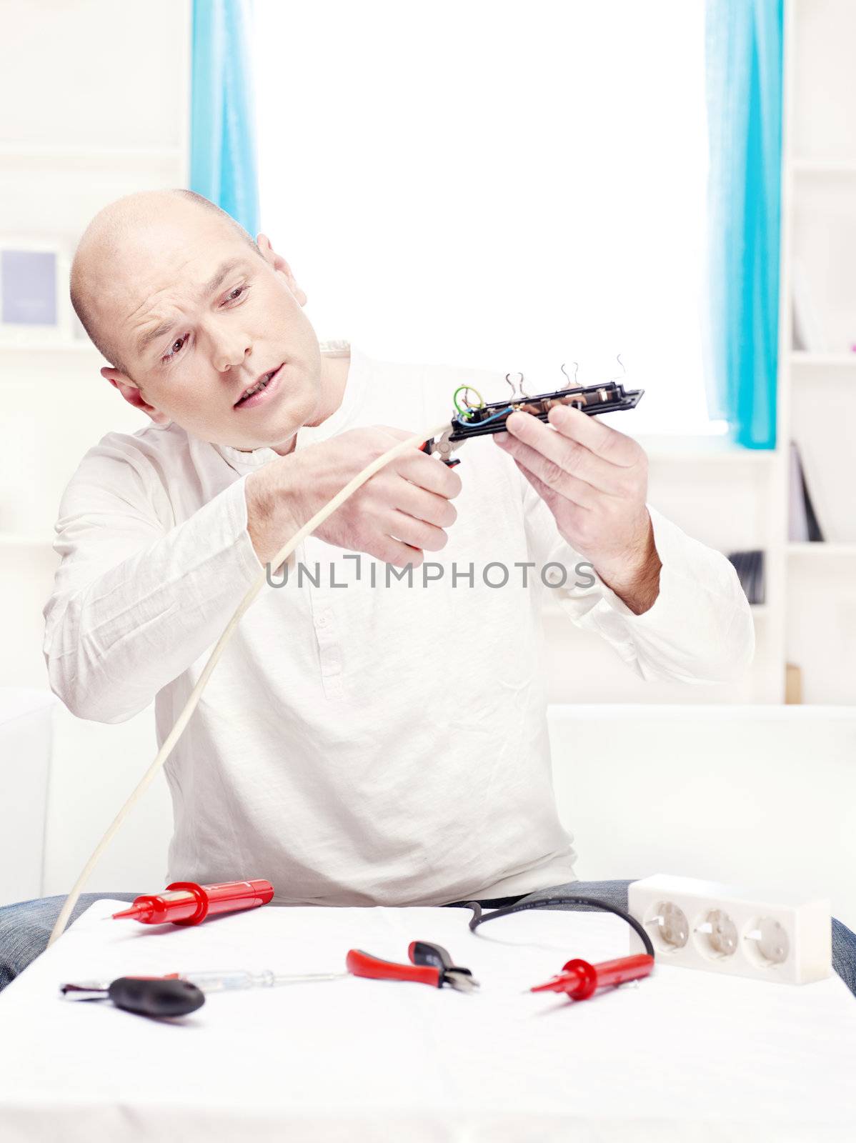 man repair an extension cord at home
