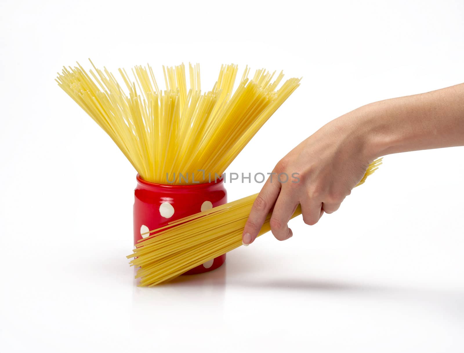 Woman's hands holding red jar full of spaghetti inside.  Isolated on a white background.