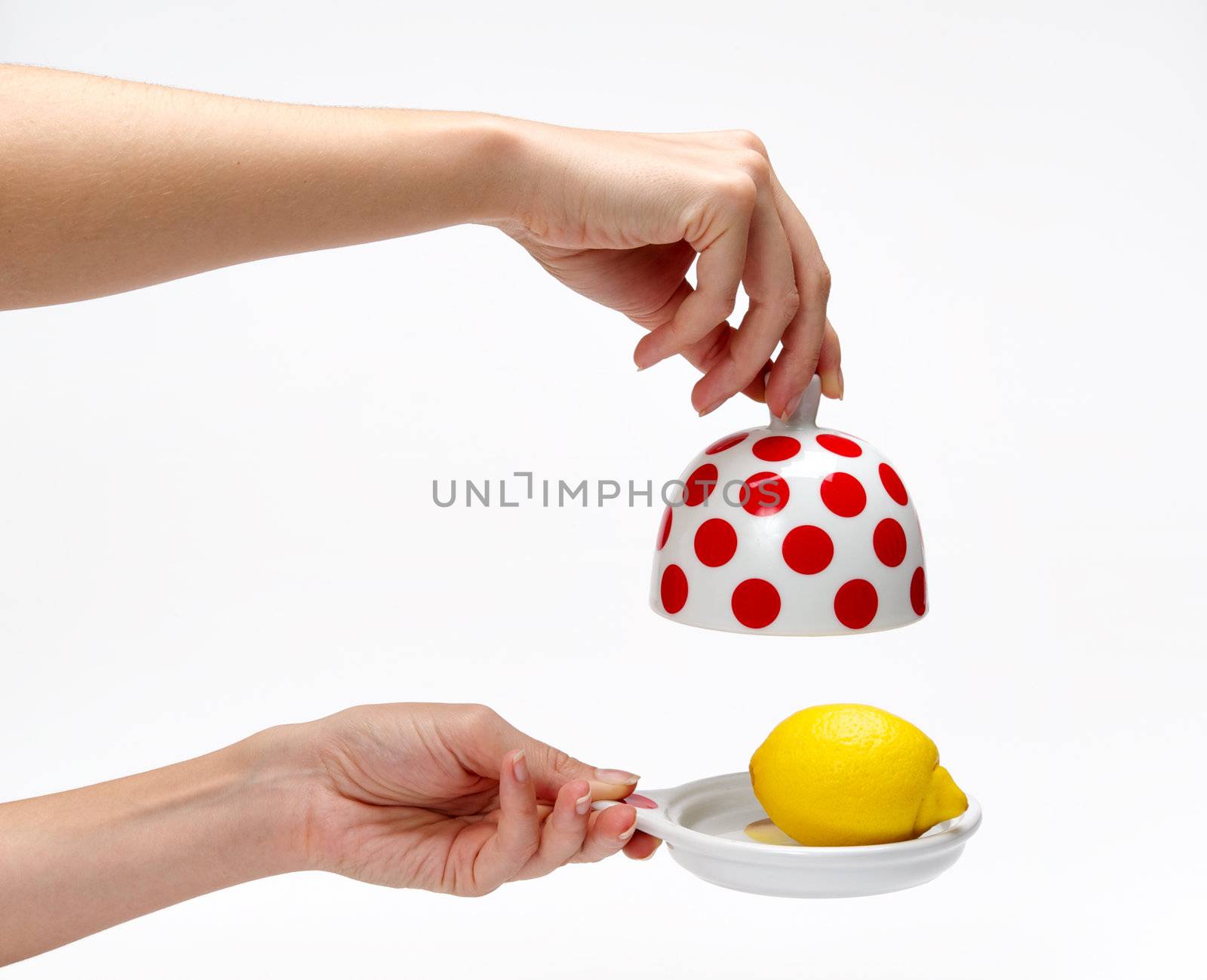 Woman's hands opening bank with lemon inside on a white background