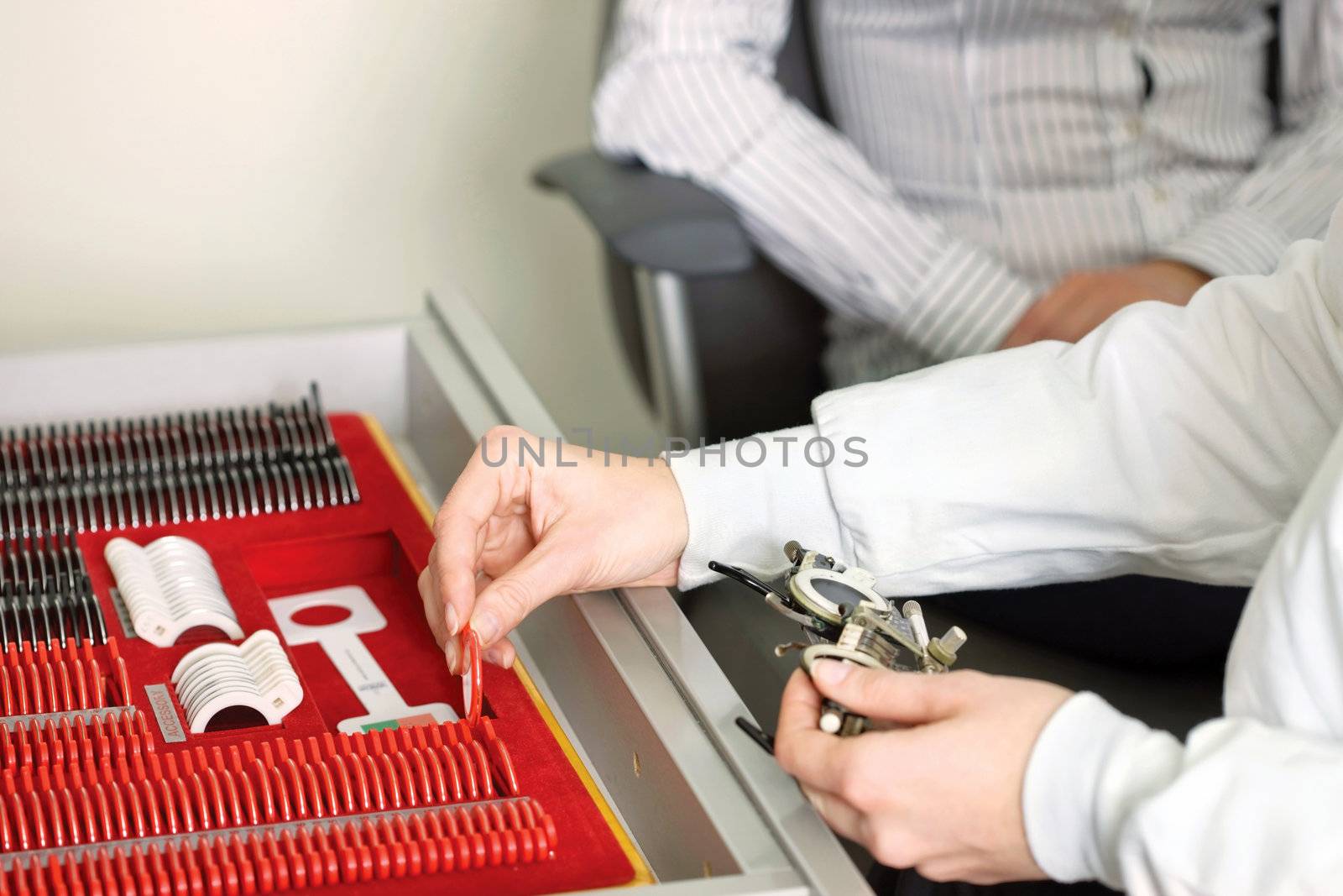 Optometrist or eye doctor about to put lens in a trial frames during a vision checkup