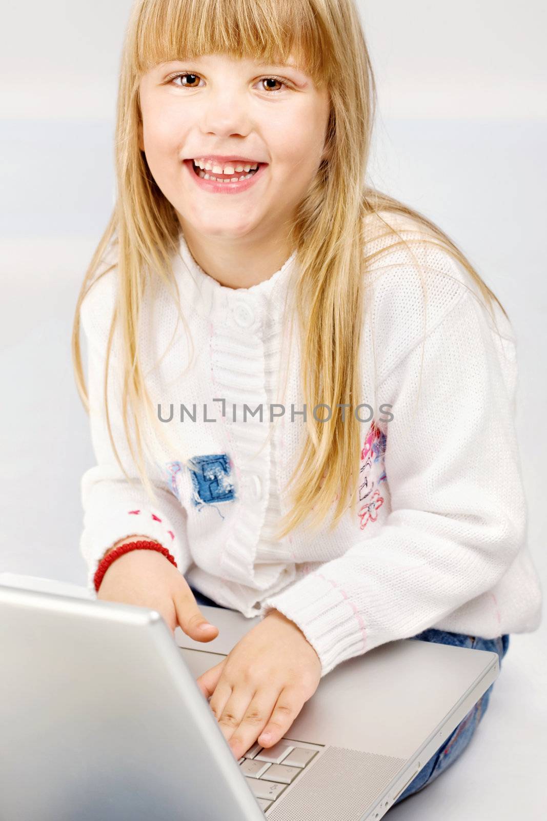 Smiled female child holding laptop