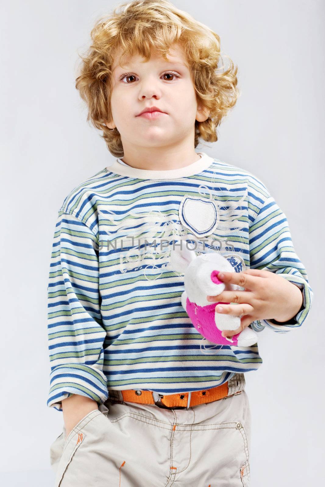 portrait of a male child with blue curl hair, holding toy and posing