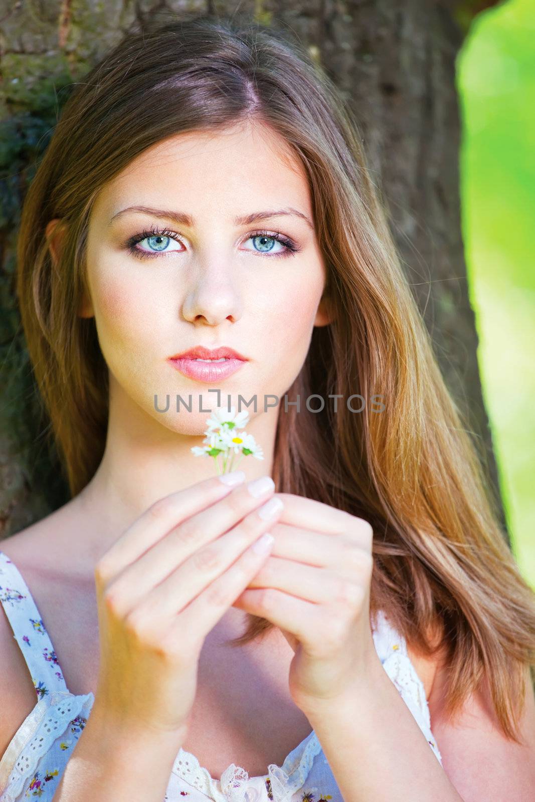 woman in park holding spring flowers by imarin