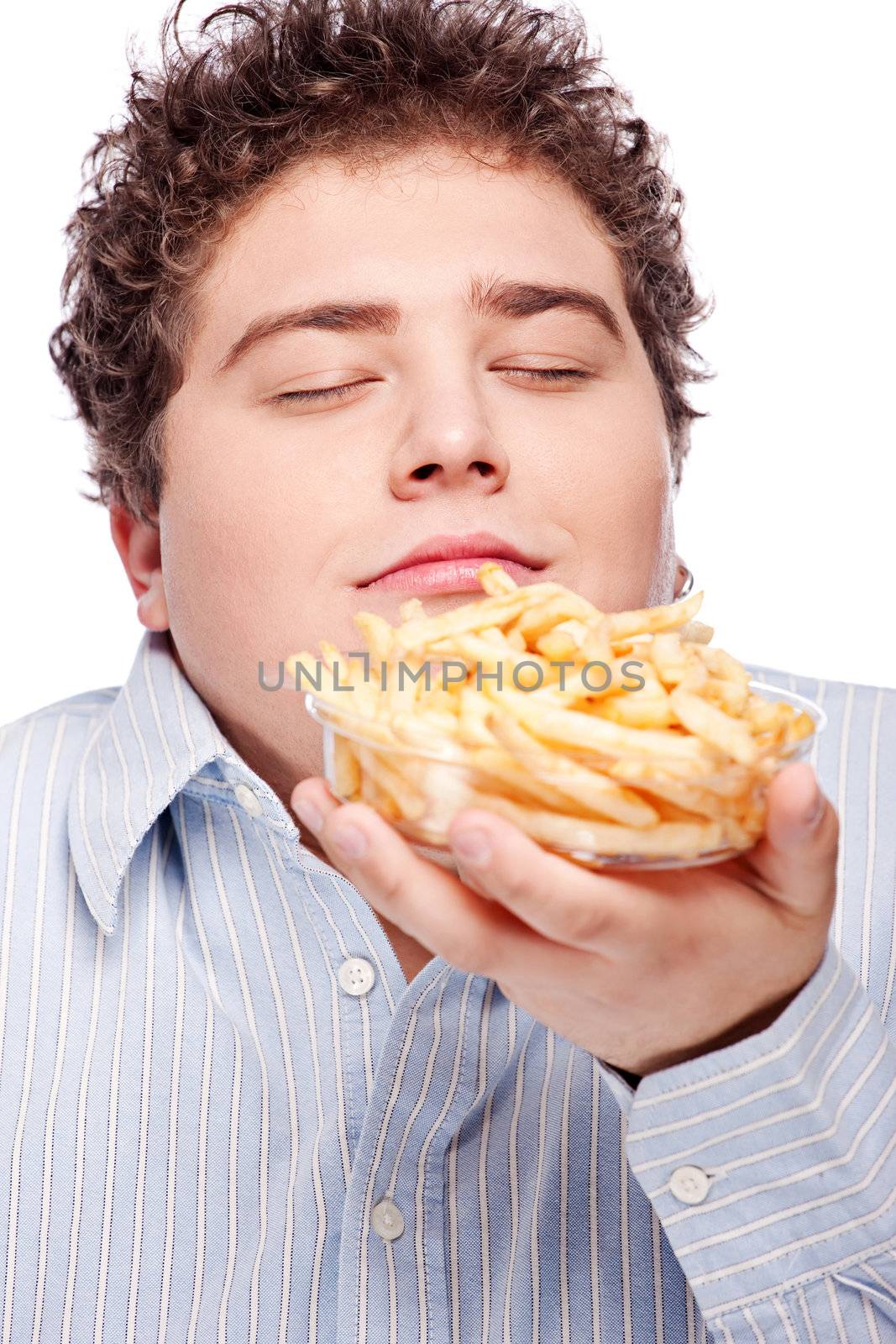 Happy young chubby man with French fries in dish, isolated on white