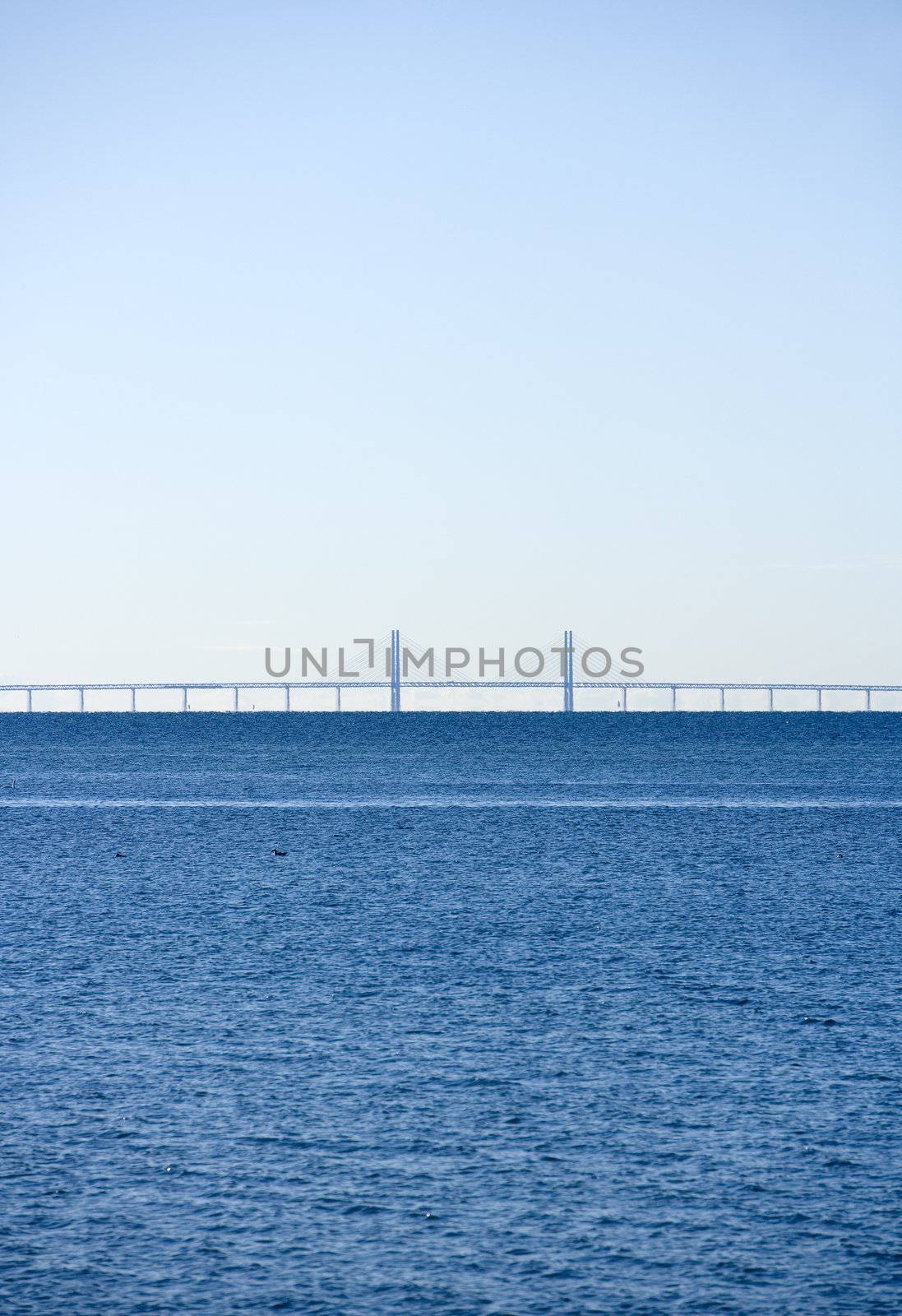 Horizon over Water on a sunny day with a bridge in the background