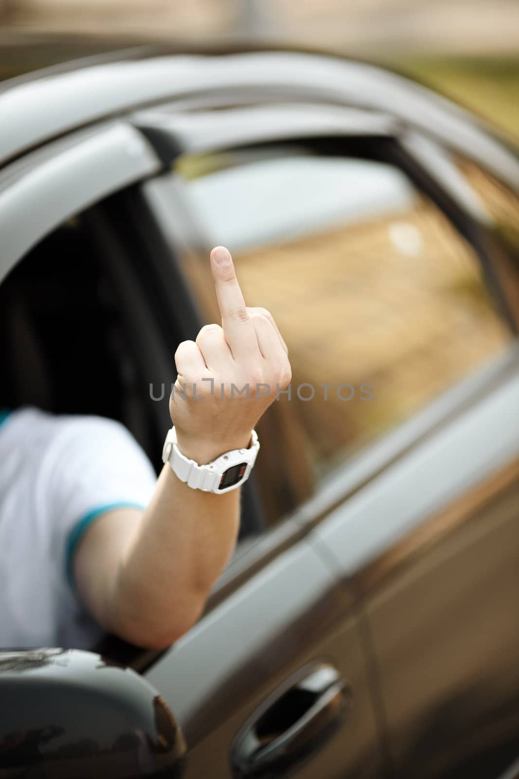 young driver shows middle finger, natural light, selective focus