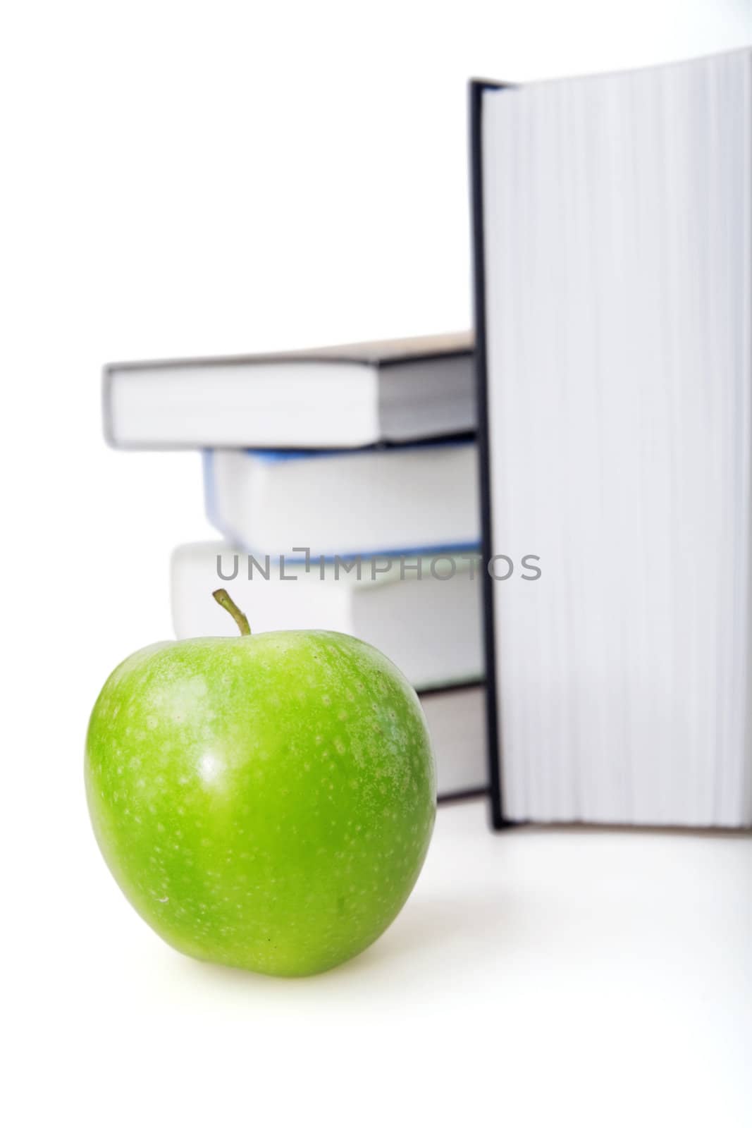 Bright green apple and books on a background by Serp