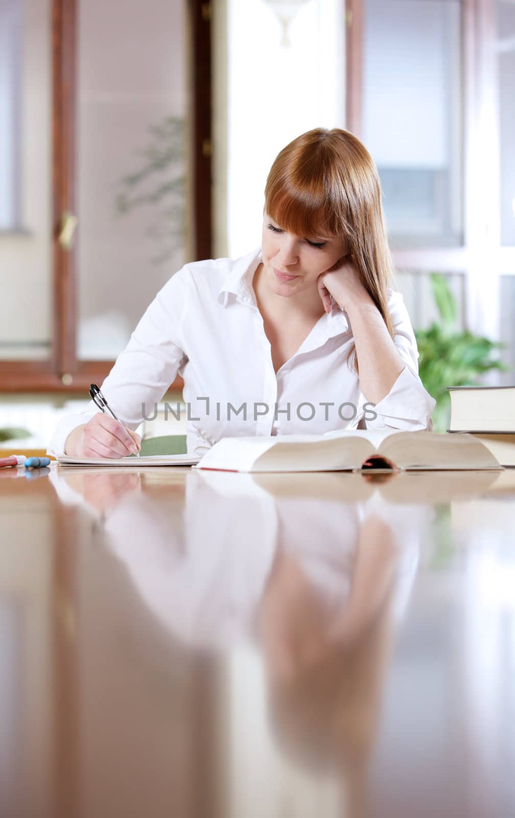 Young student doing her homework at a table