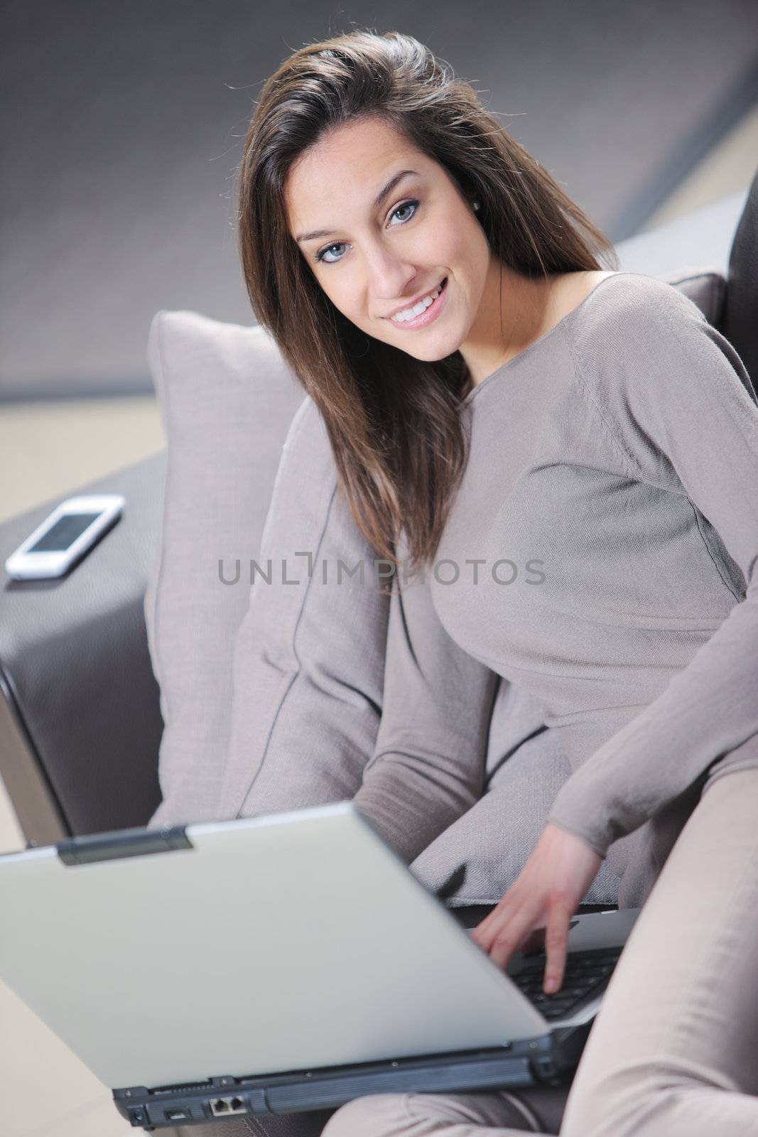 Smiling woman using her laptop in the living room.