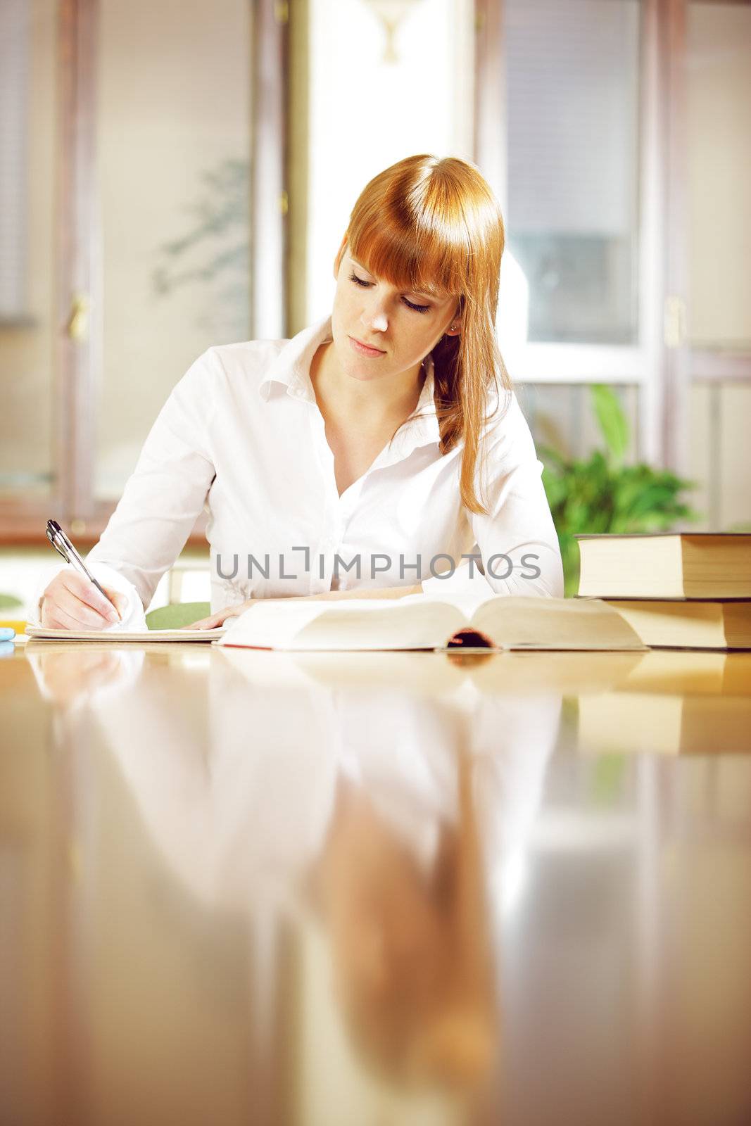 Young student doing her homework at a table 
