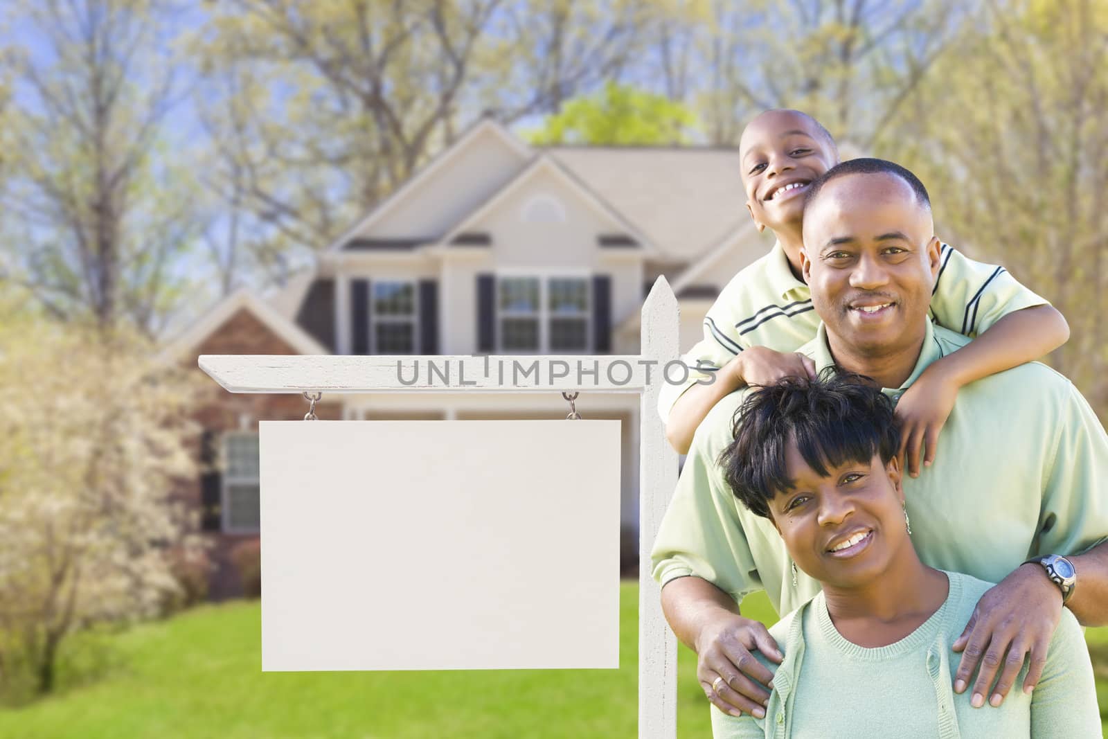 African American Family In Front of Blank Real Estate Sign and New House - Ready for Your Own Text.
