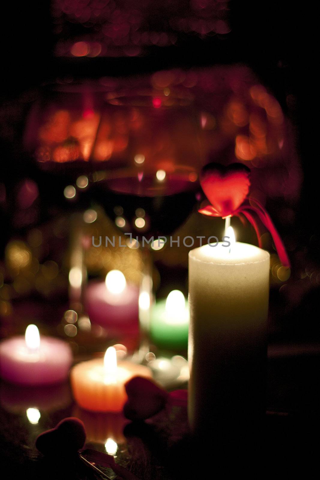 romantically colored candles burning with a beautiful reddish bokeh