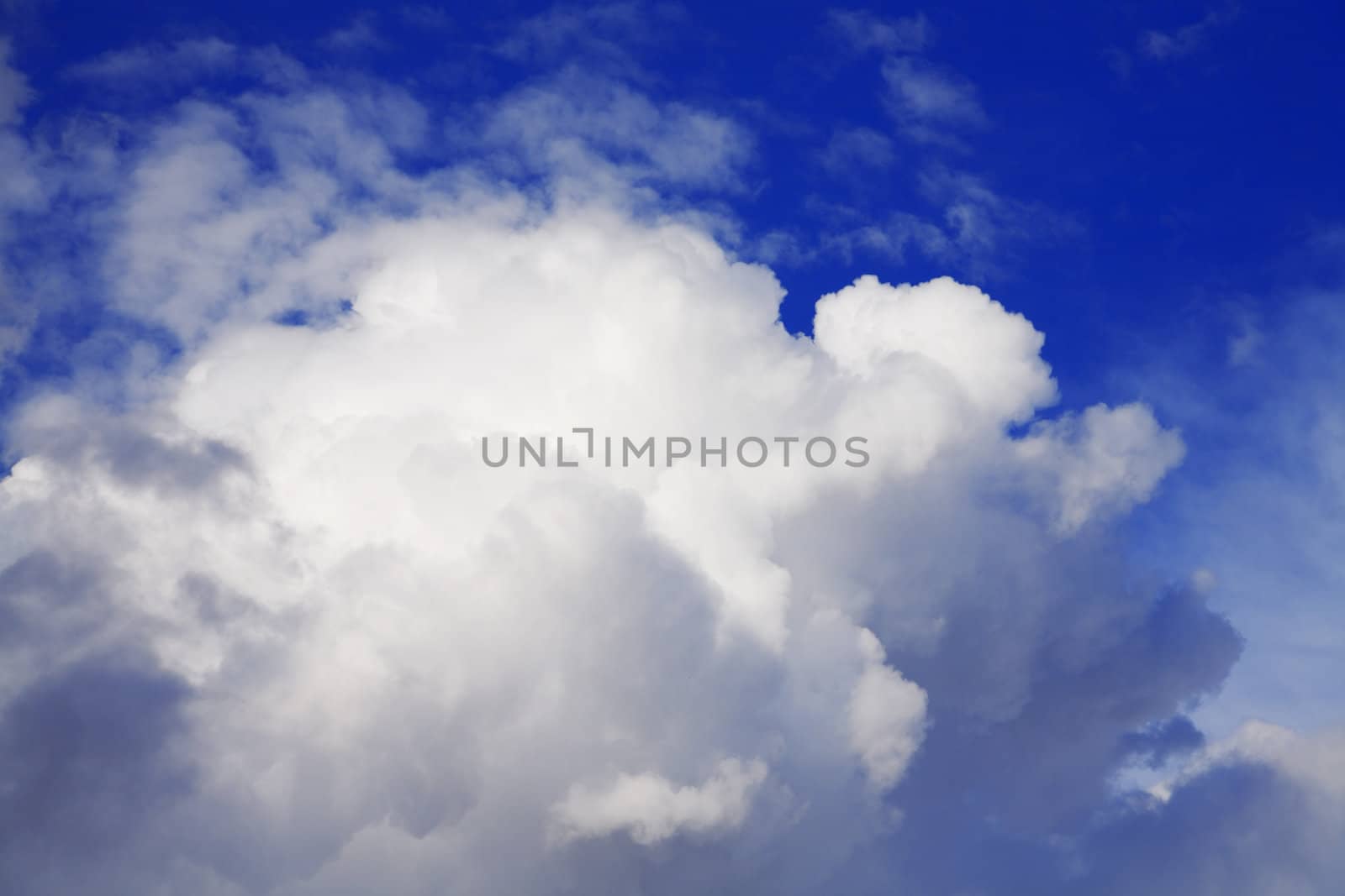 cumulus clouds soaring on the dark blue sky