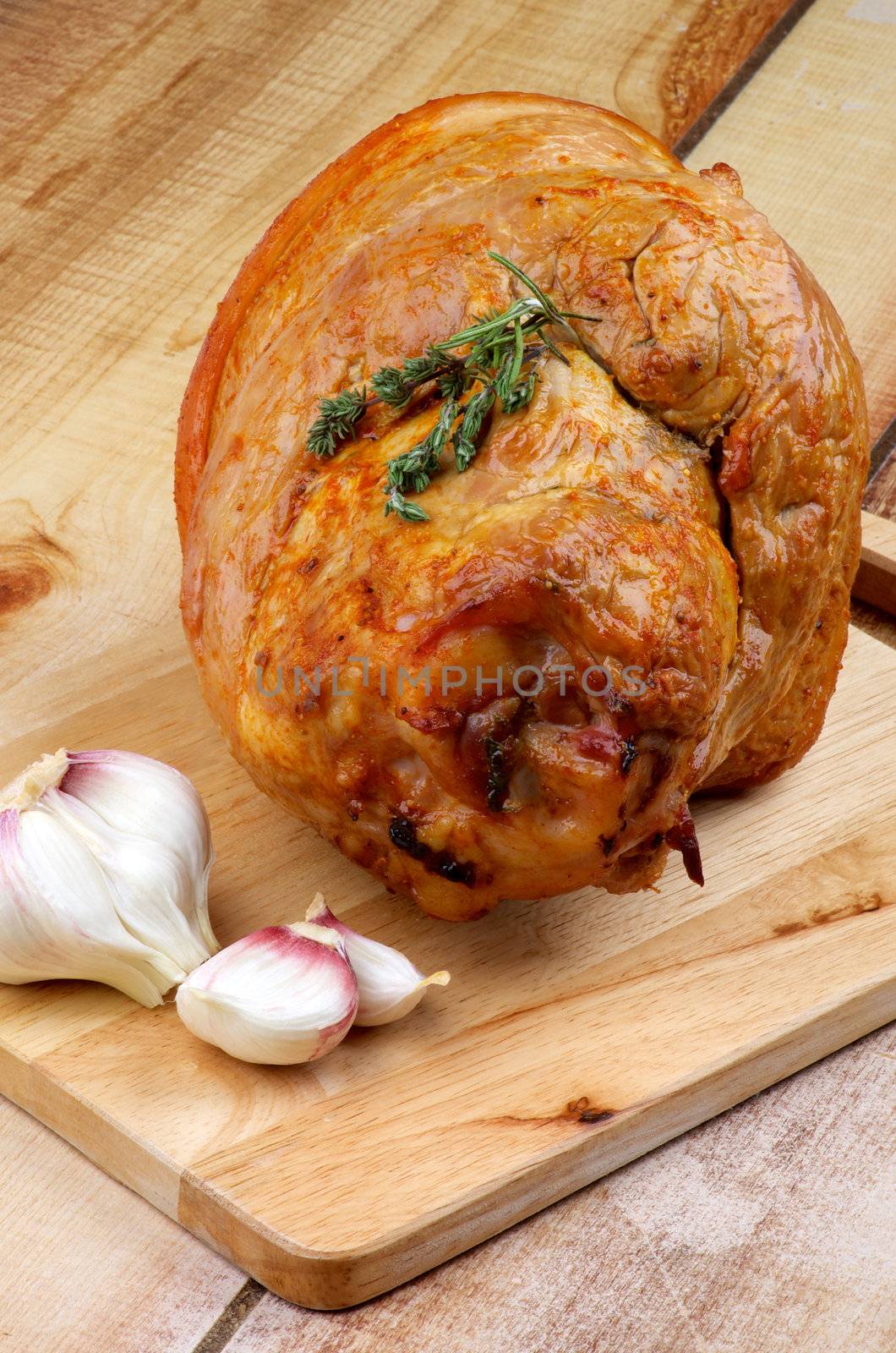 Delicious Roasted Pork Knuckle Glazed with Spices and Garlic closeup on Cutting Board
