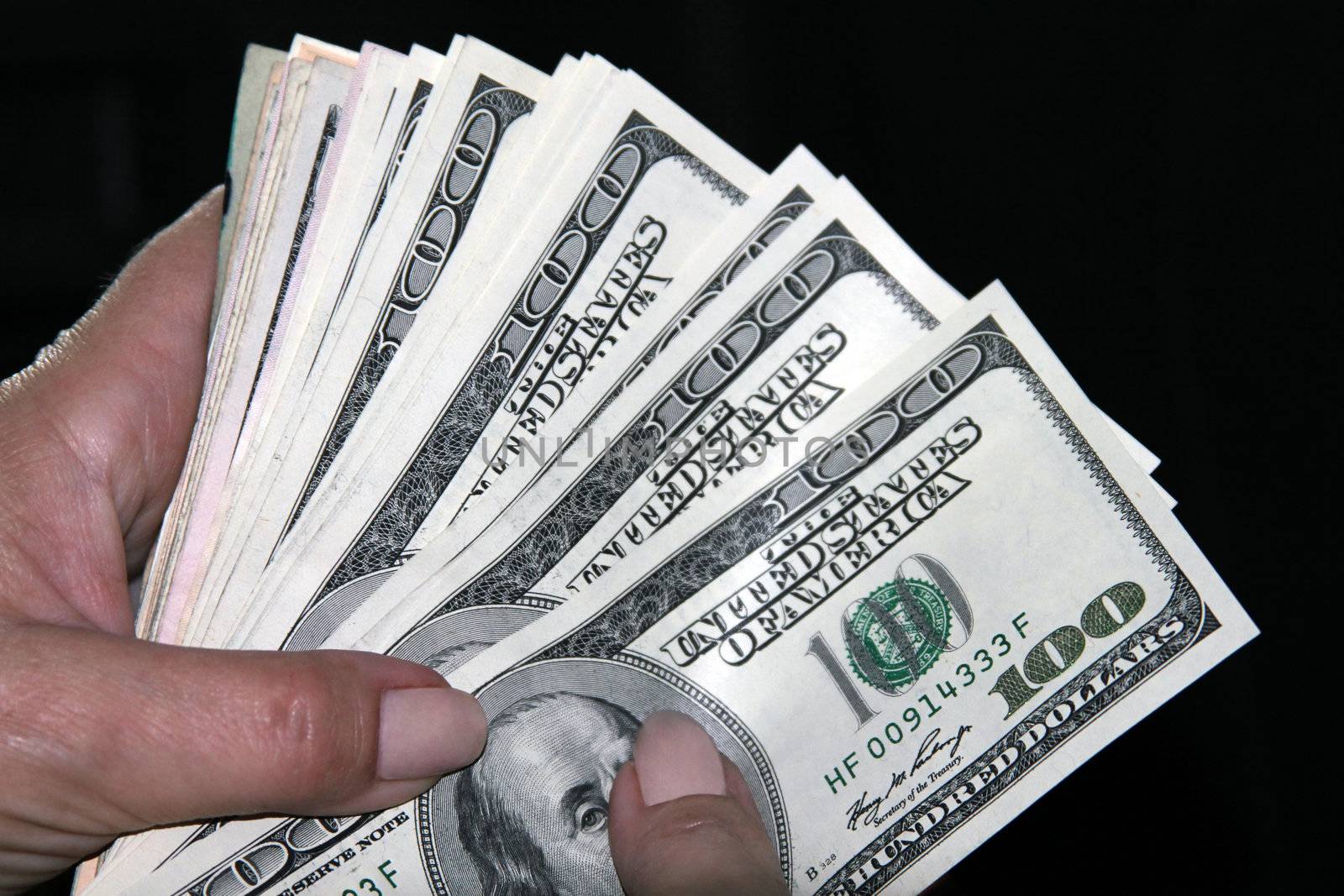 Woman hand holding american money on black background
