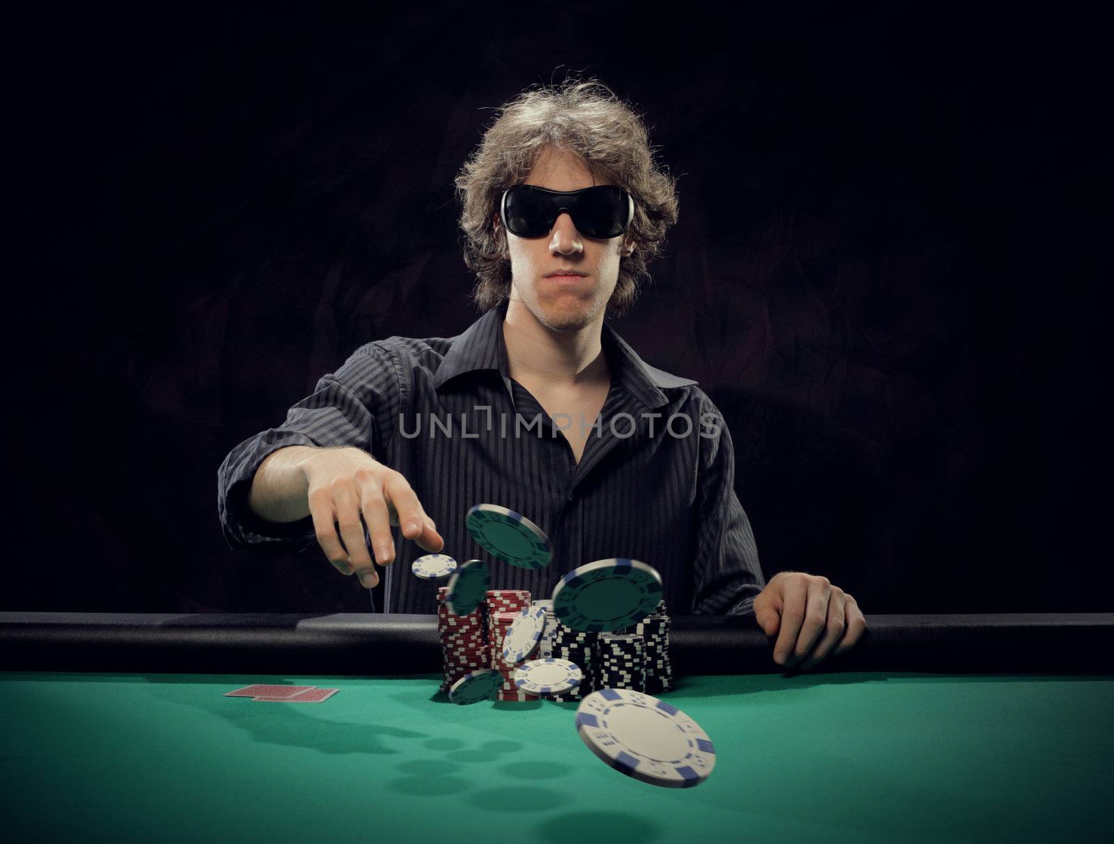 Poker player at a poker table throwing his chips