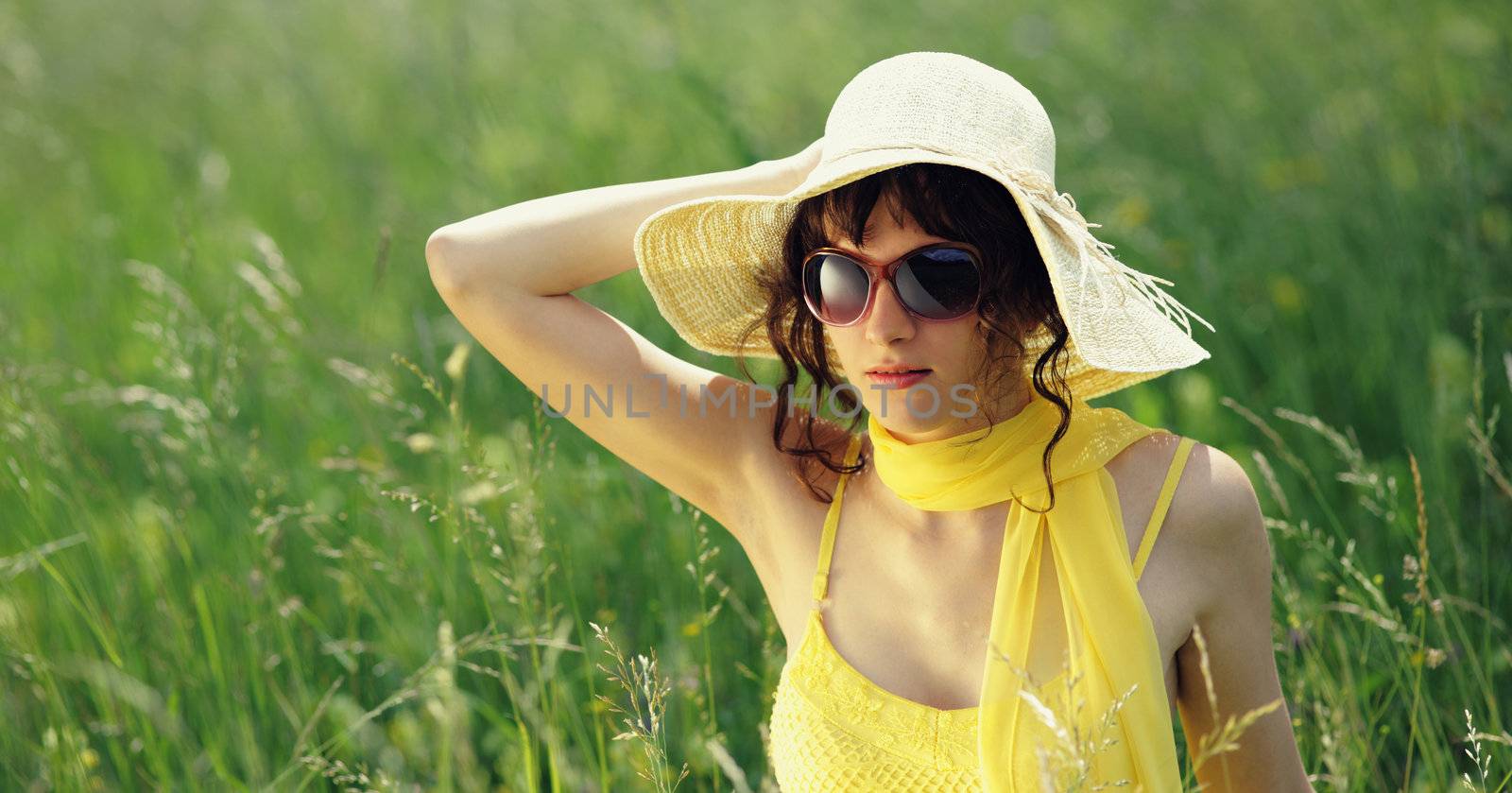 young woman in sunglasses in a flowers field 