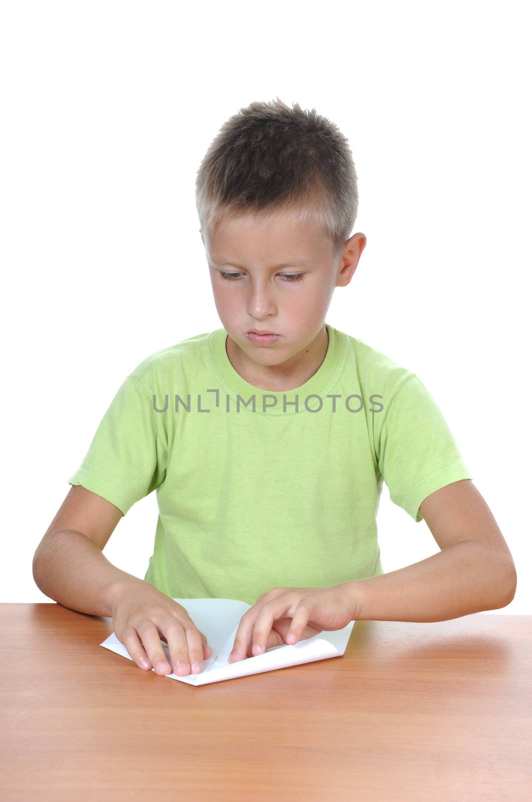 The boy with the paper behind a table over white