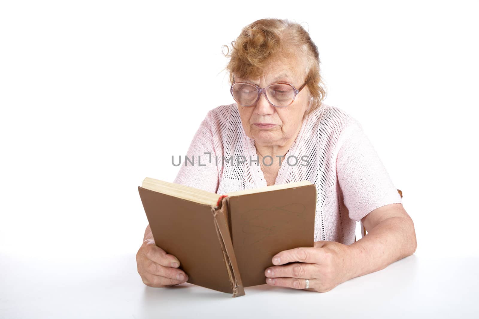 old woman in glasses reads the book on a white background