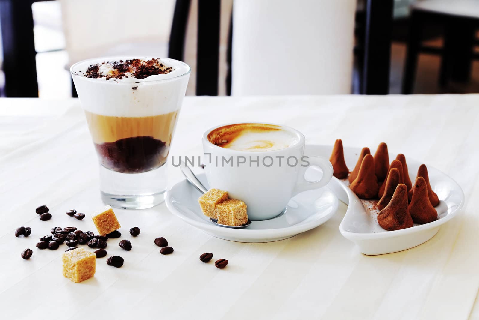 coffee and sweat candies on white table by Serp