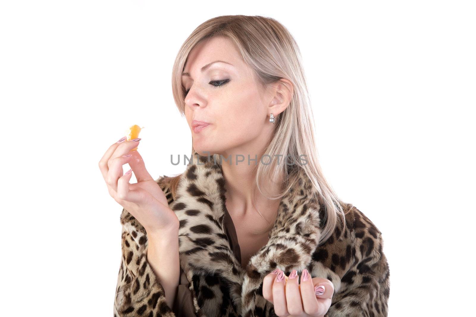 The girl in  fur coat holds in hand  tangerine on  white background