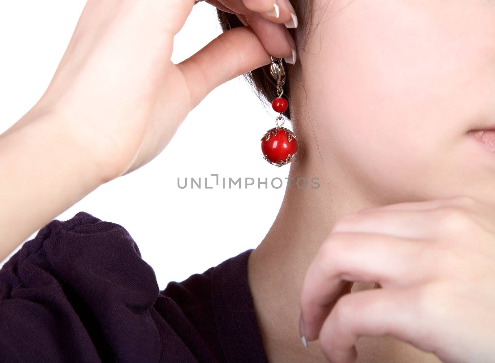 Hands of the girl hold an earring on a white background