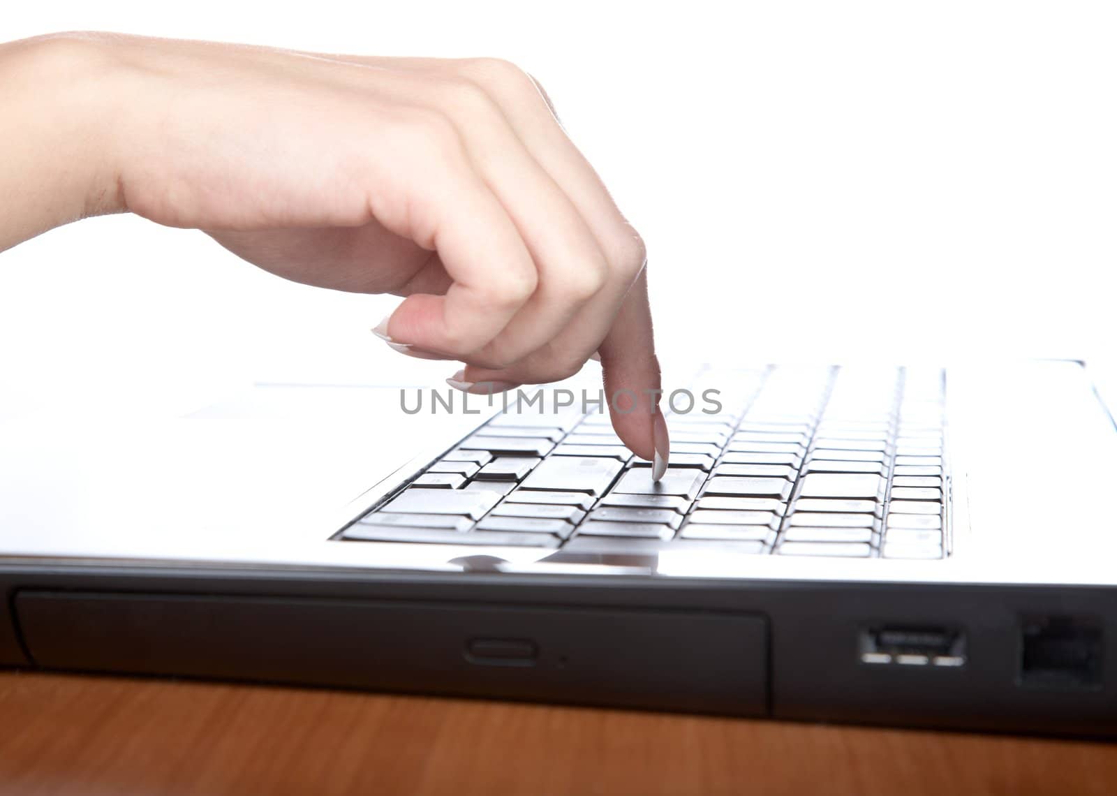 Female hand with a nail on the laptop keyboard