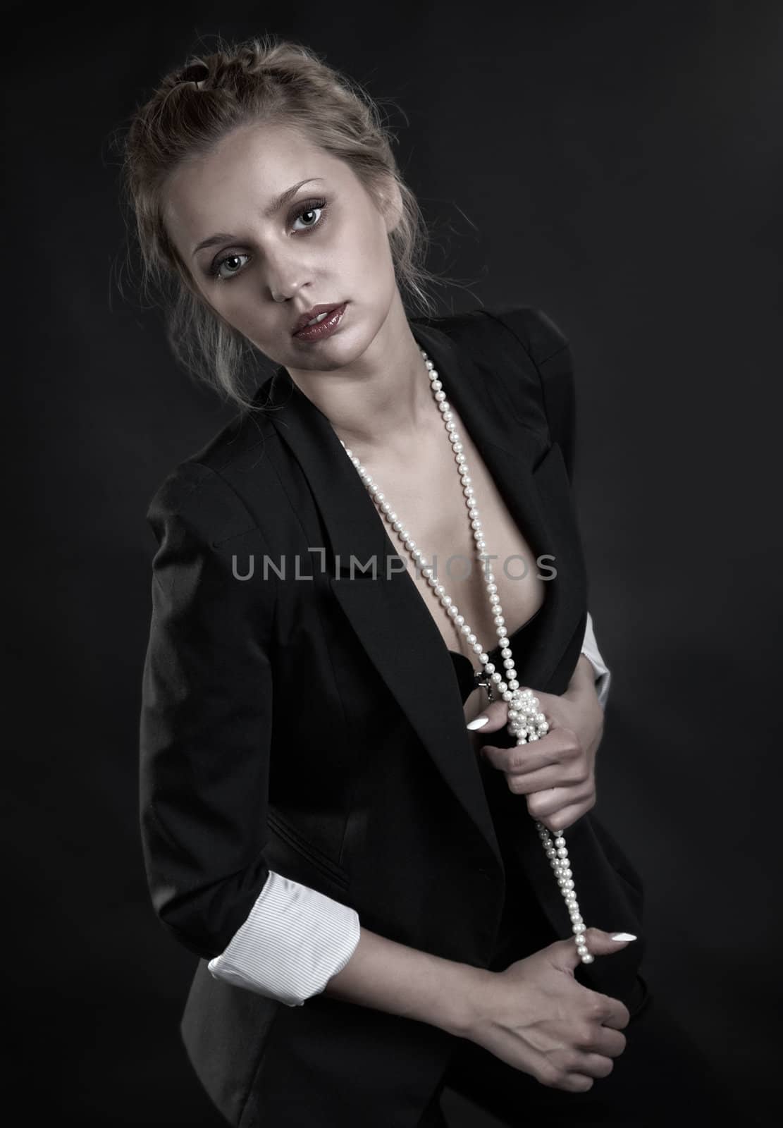 The girl in a brassiere and  beads on  black background