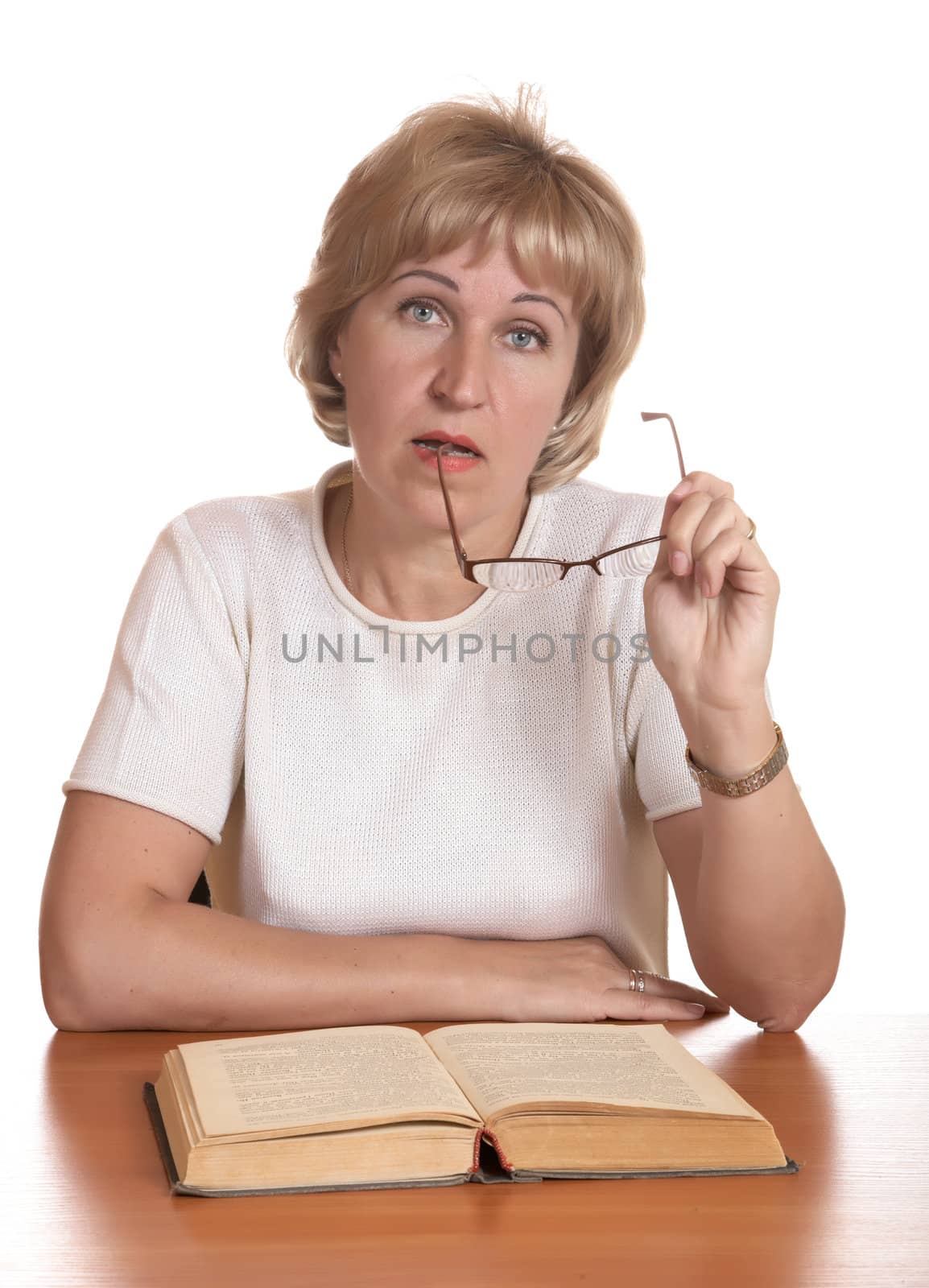 The mature woman with  book behind a table on white background