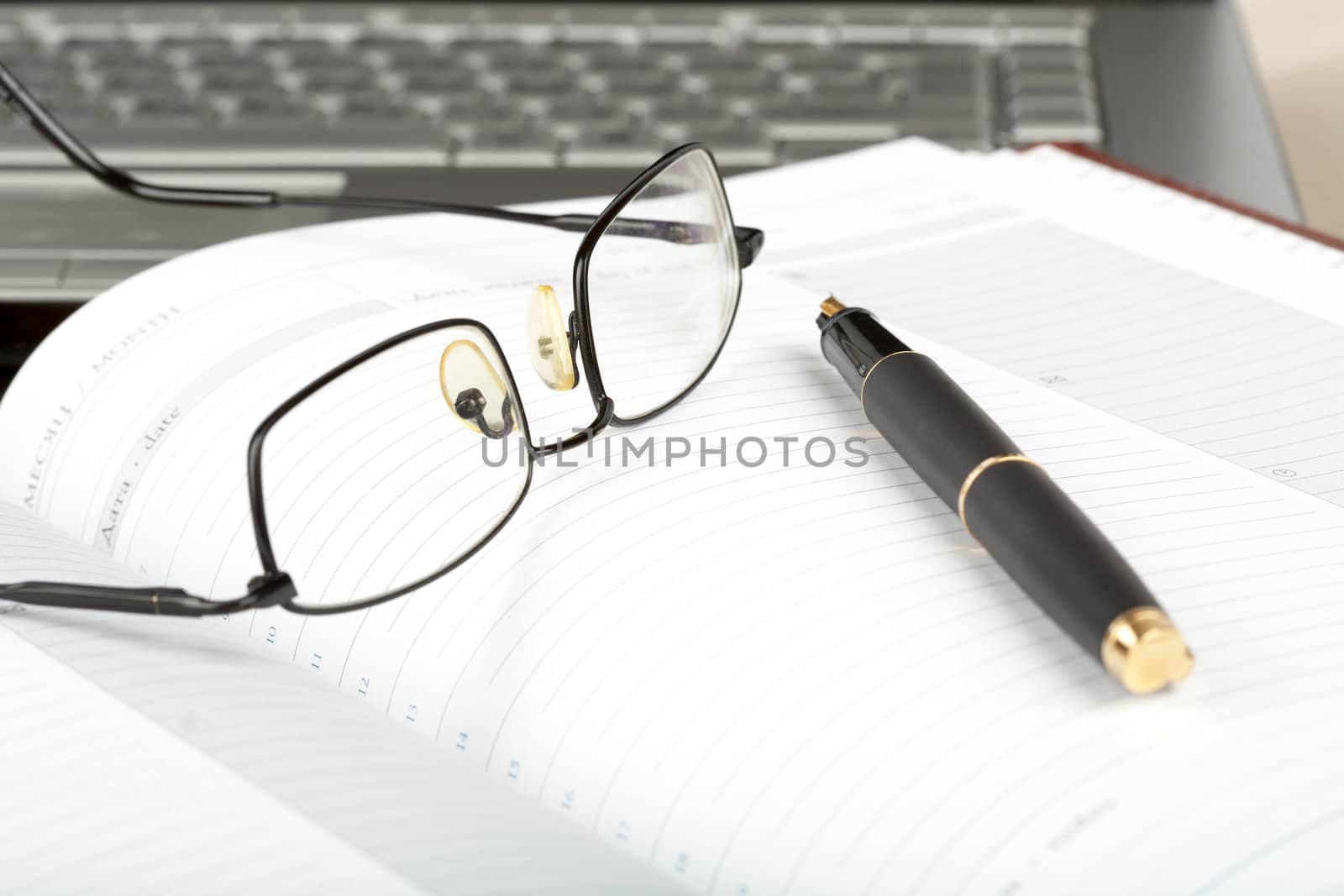 Organizer, glasses,pen and notebook on a desk