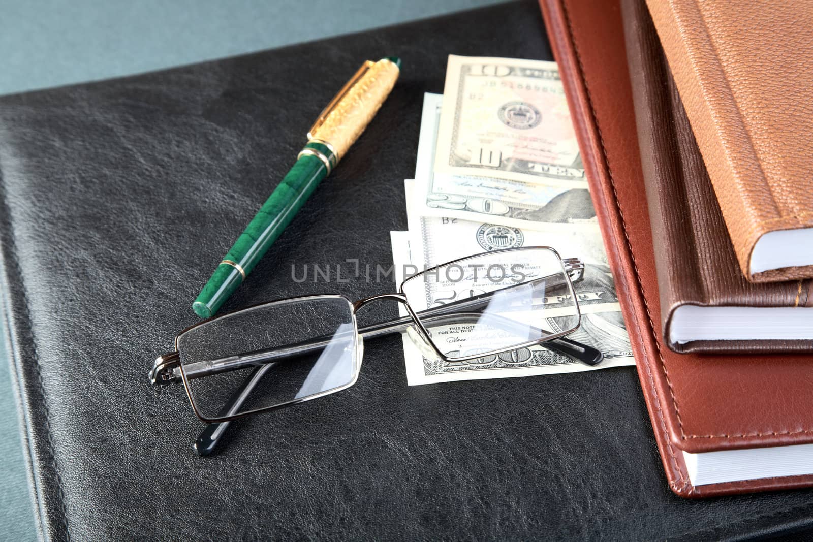 Folder organizers glasses  pen and money on a table