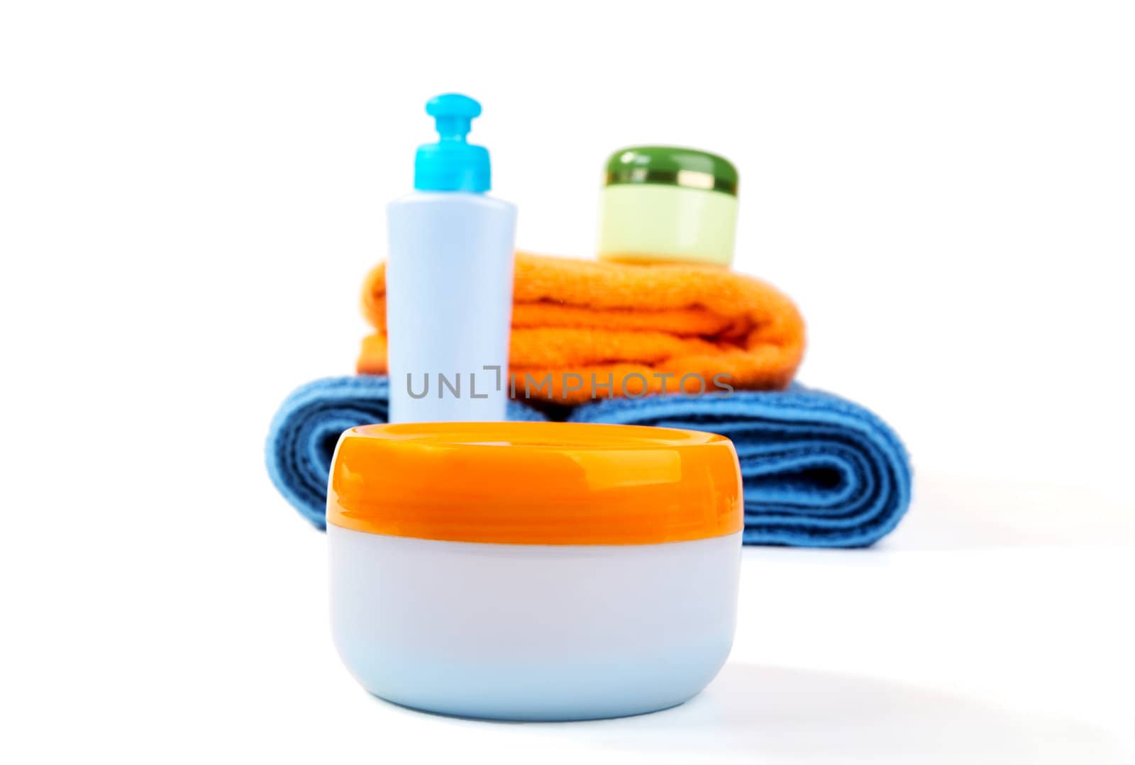 Terry towels and tubes with cosmetics isolated on a white background