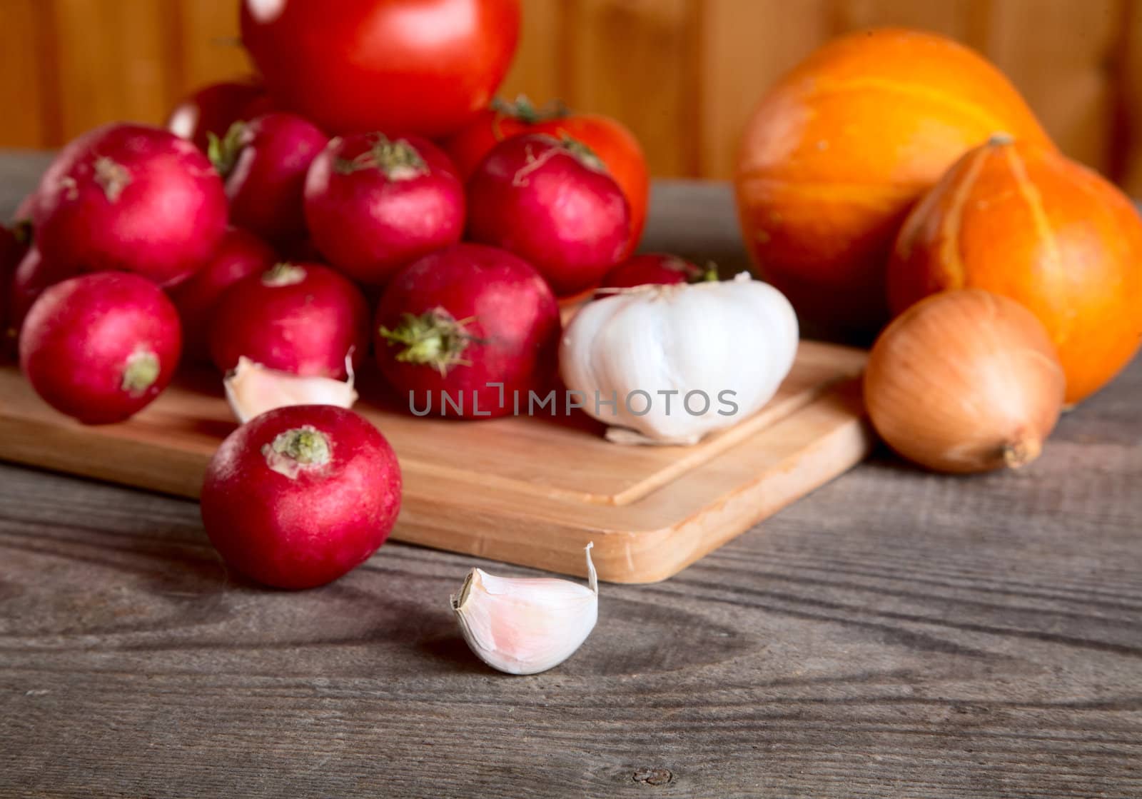 Onions garlic  garden radish on a table from unplaned boards