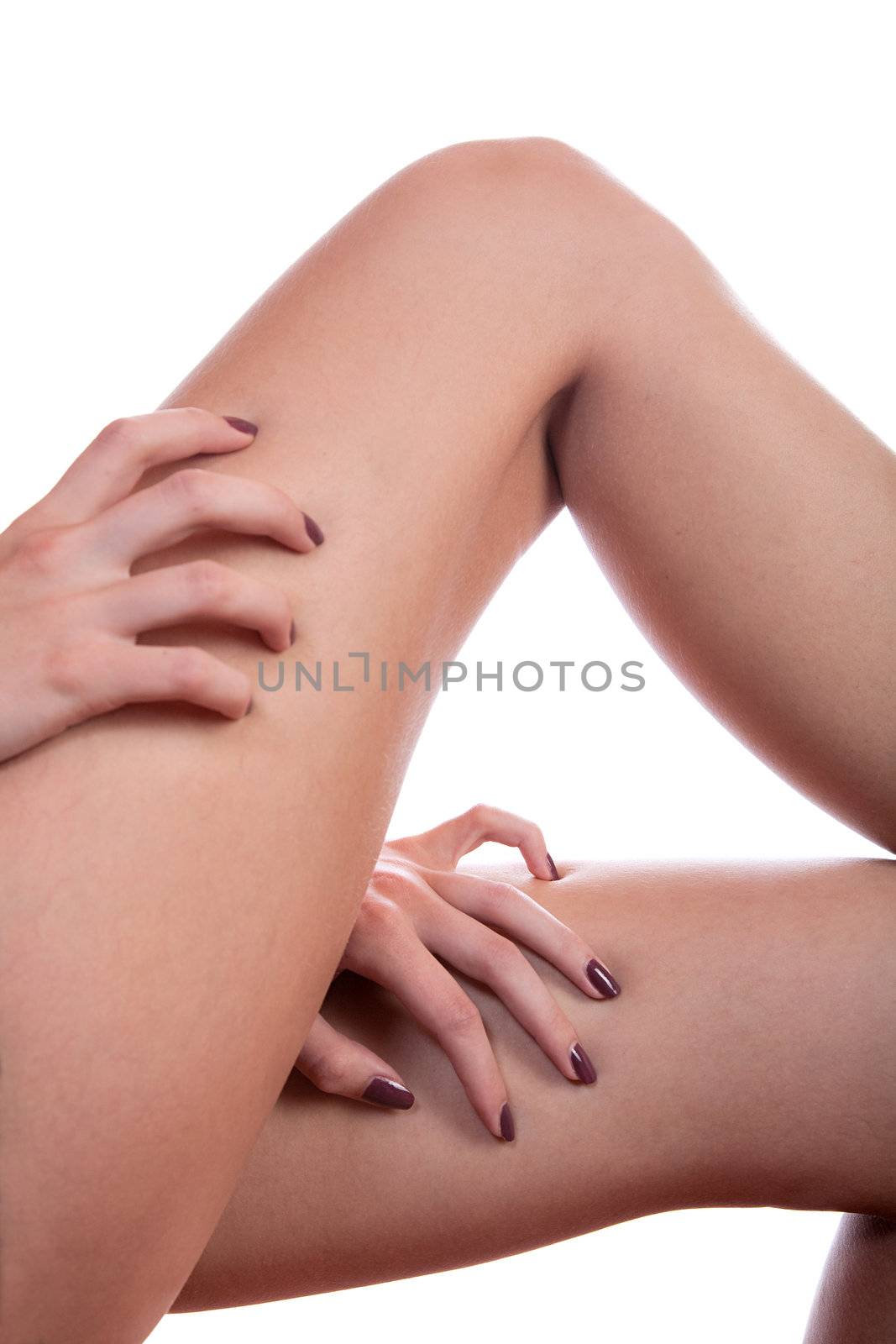 Hands of the girl stick nails into a leg on  white background