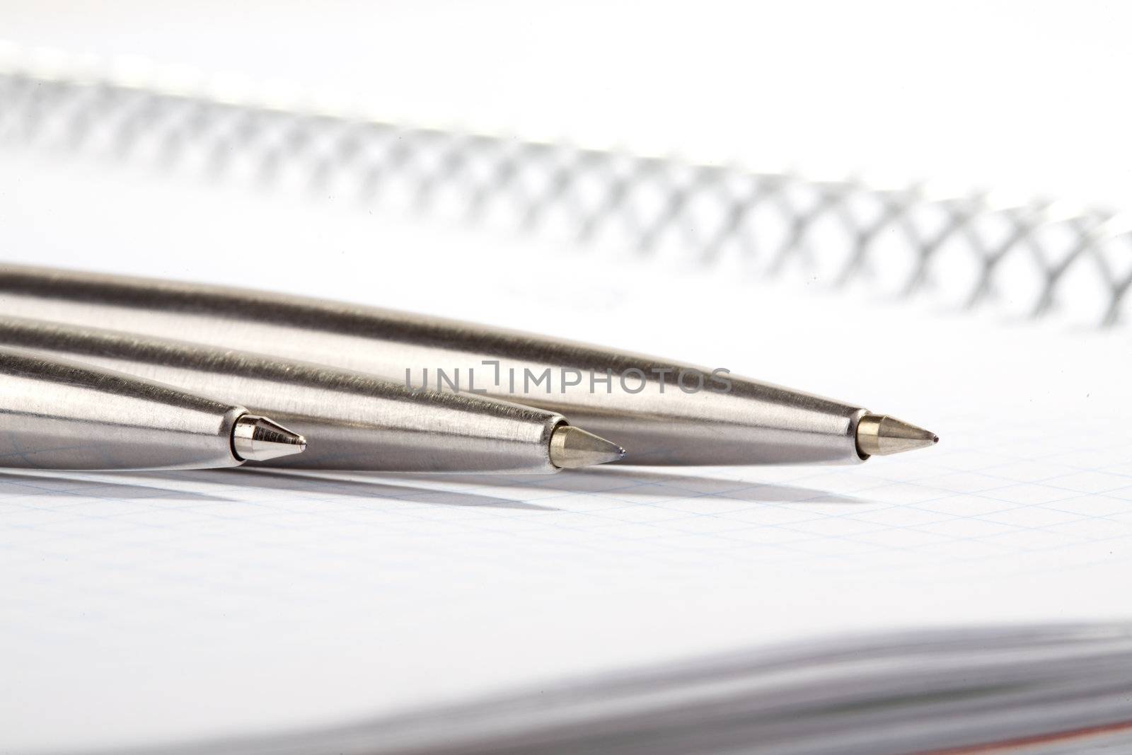 line of ball-point pens lays on a writing-book