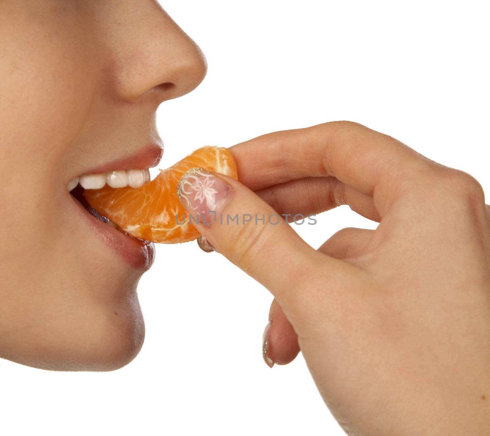 The girl biting a segment of  tangerine on white background