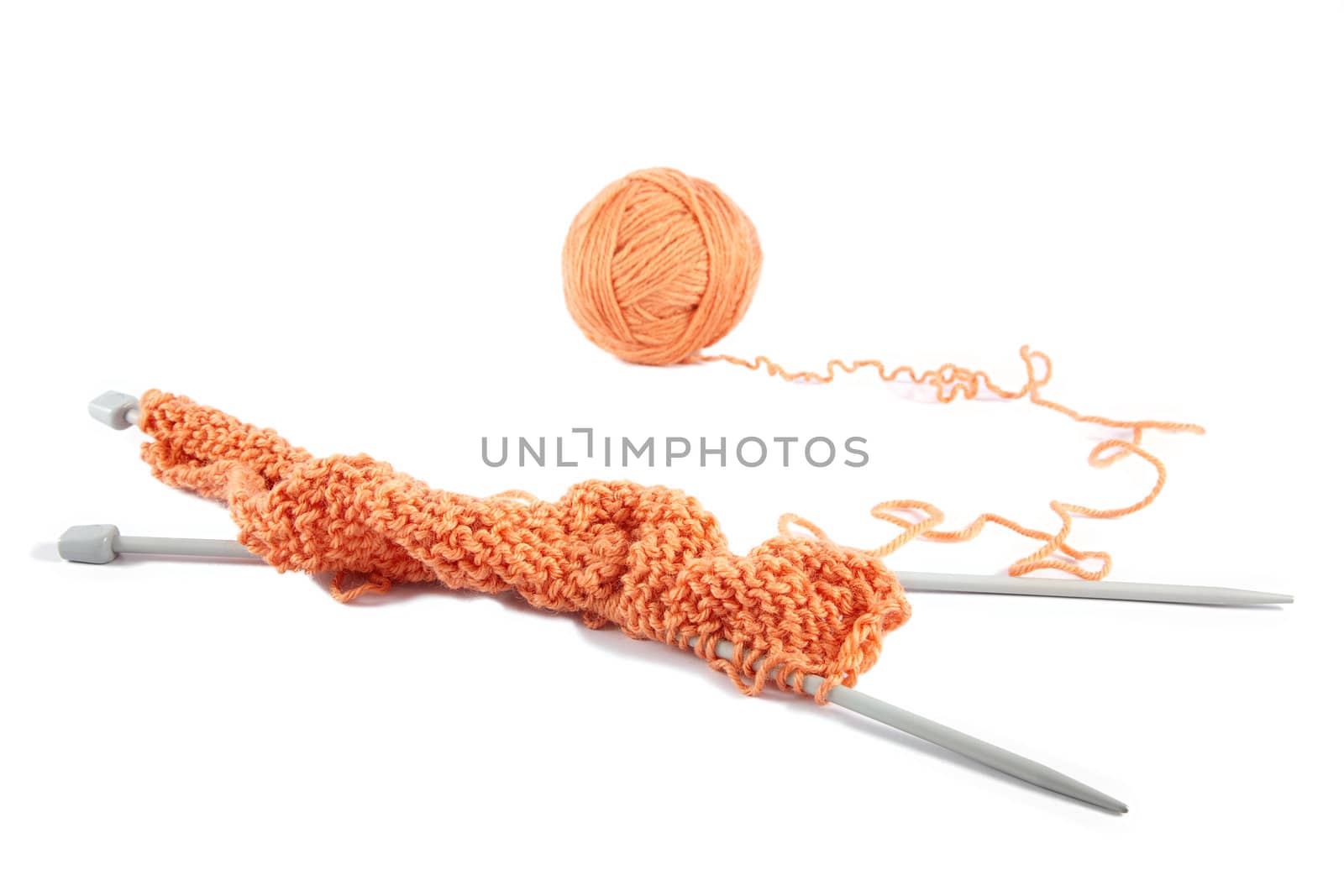 Knitting spokes with ball of wool on white background