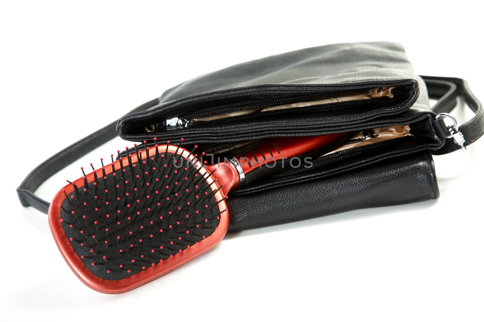 Female bag and hairbrush isolated on a white background
