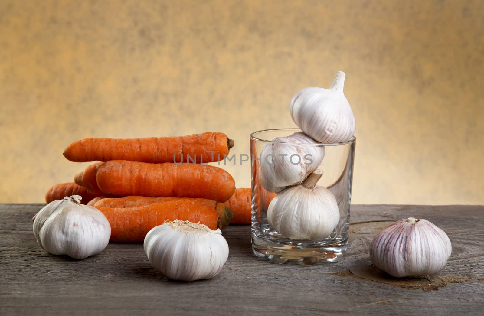 Still-life with garlic and a glass on  wooden table