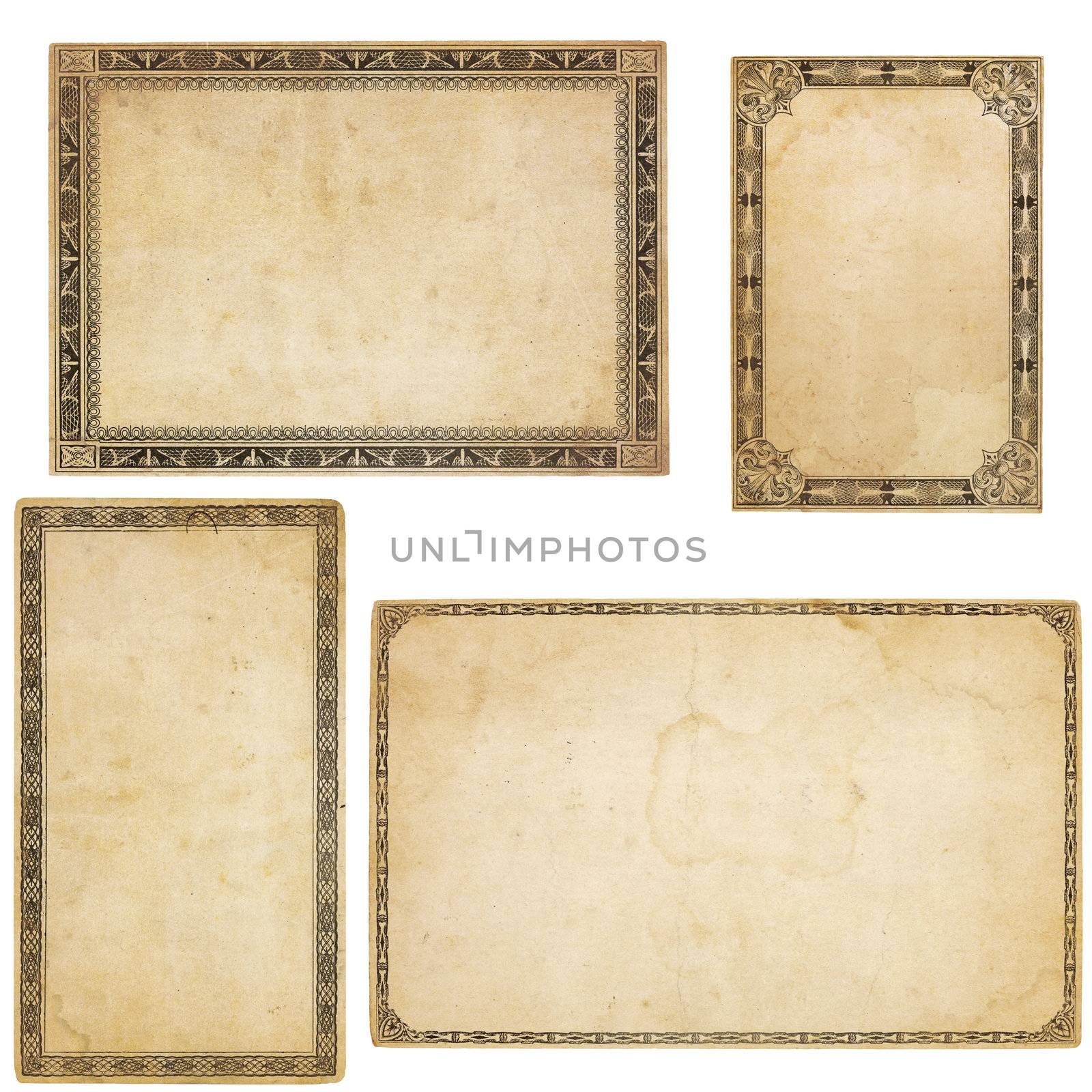 A set of four heavily aged blank cards with stains, creases and tears.  Each card has different, old-fashioned decorative border. Isolated on white. Includes clipping paths.