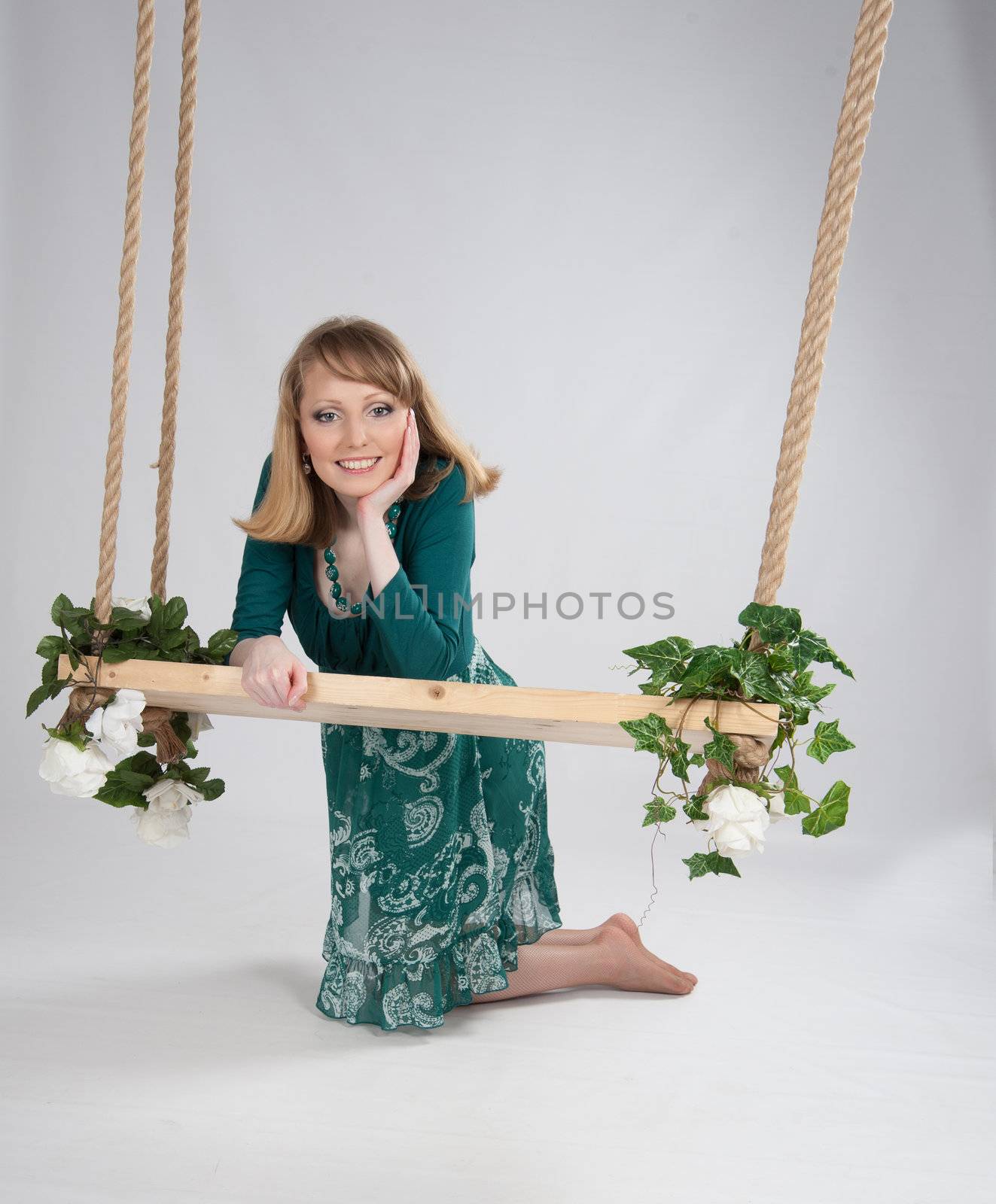 beautiful woman in a green dress on a swing