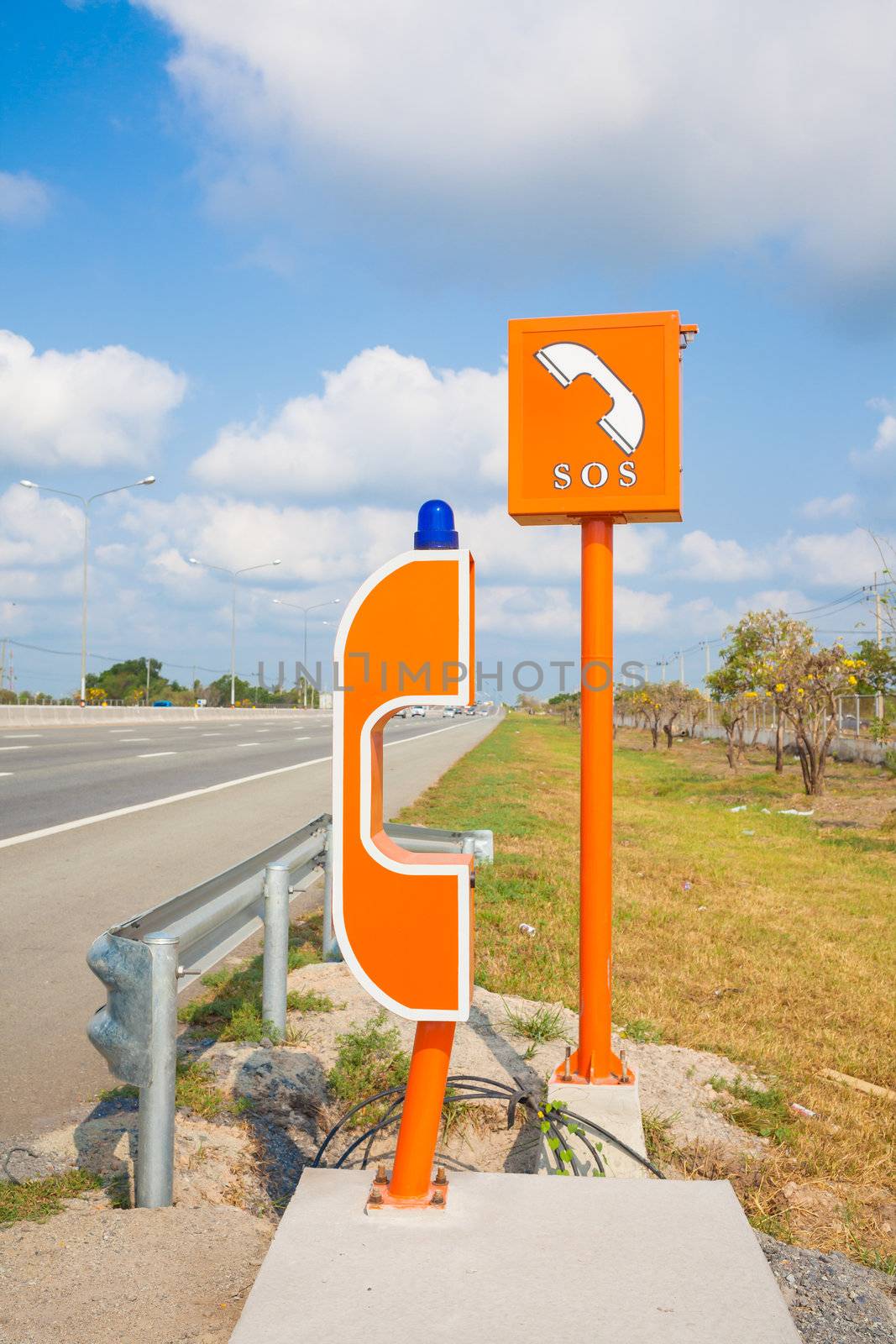 SOS sign and phone box on highway, road safety
